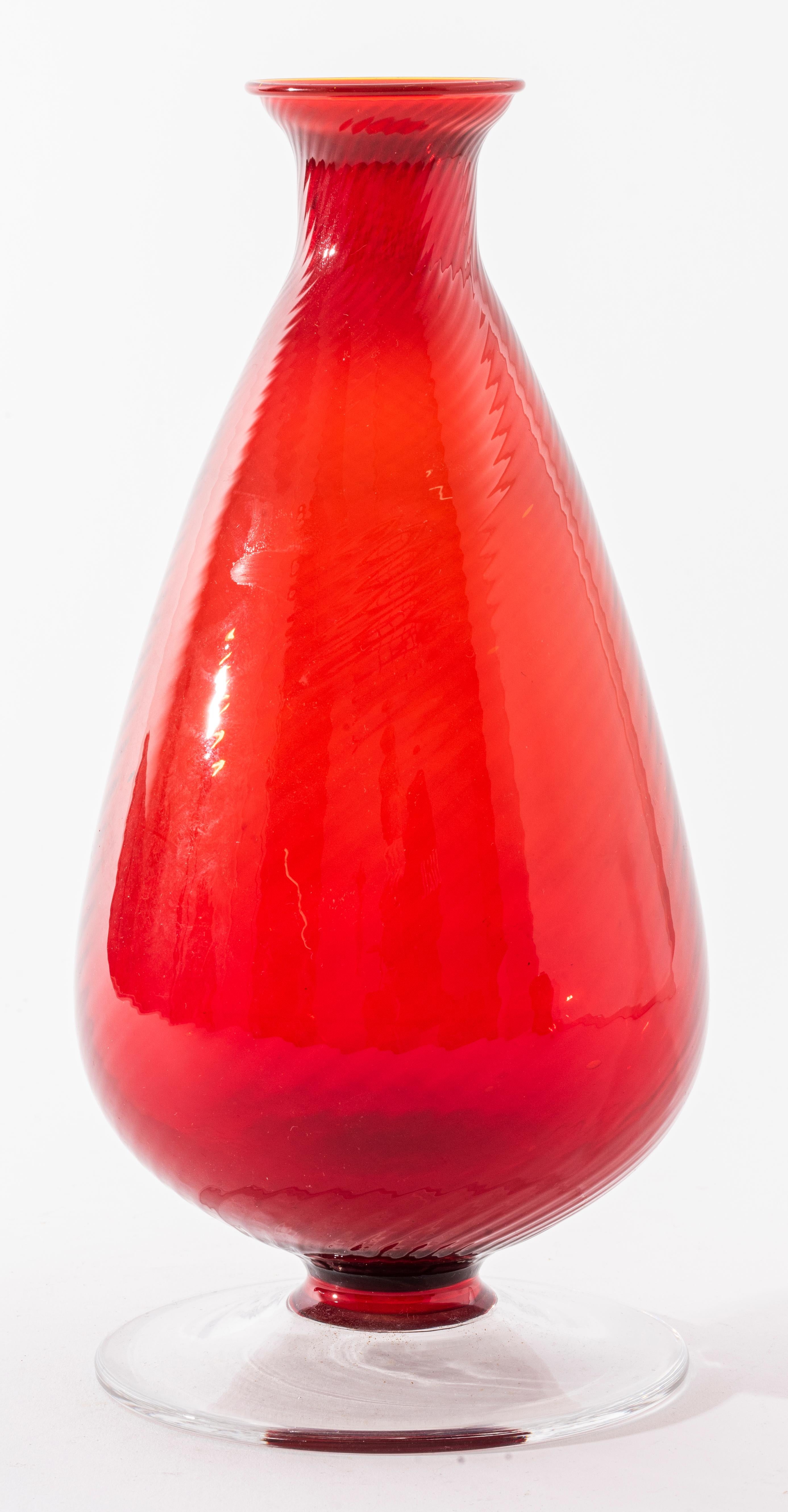 Italian Murano modern art glass bottle-shaped vase in red glass with clear glass base. Measures: 10.25