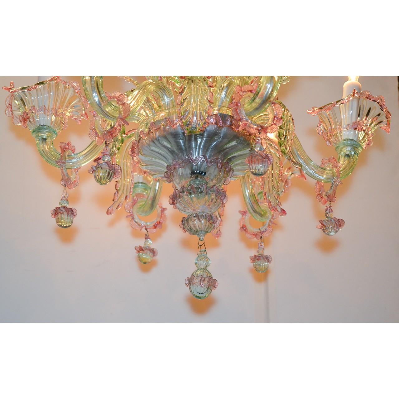 Beautiful Italian Murano glass chandelier in hues of rose, blue, lavender, and green. The vase-shaped crown atop a tapered and bulbous stem that lead to large and colorful leaf sprays. Mounted with six scrolling arms accented with unique glass rings