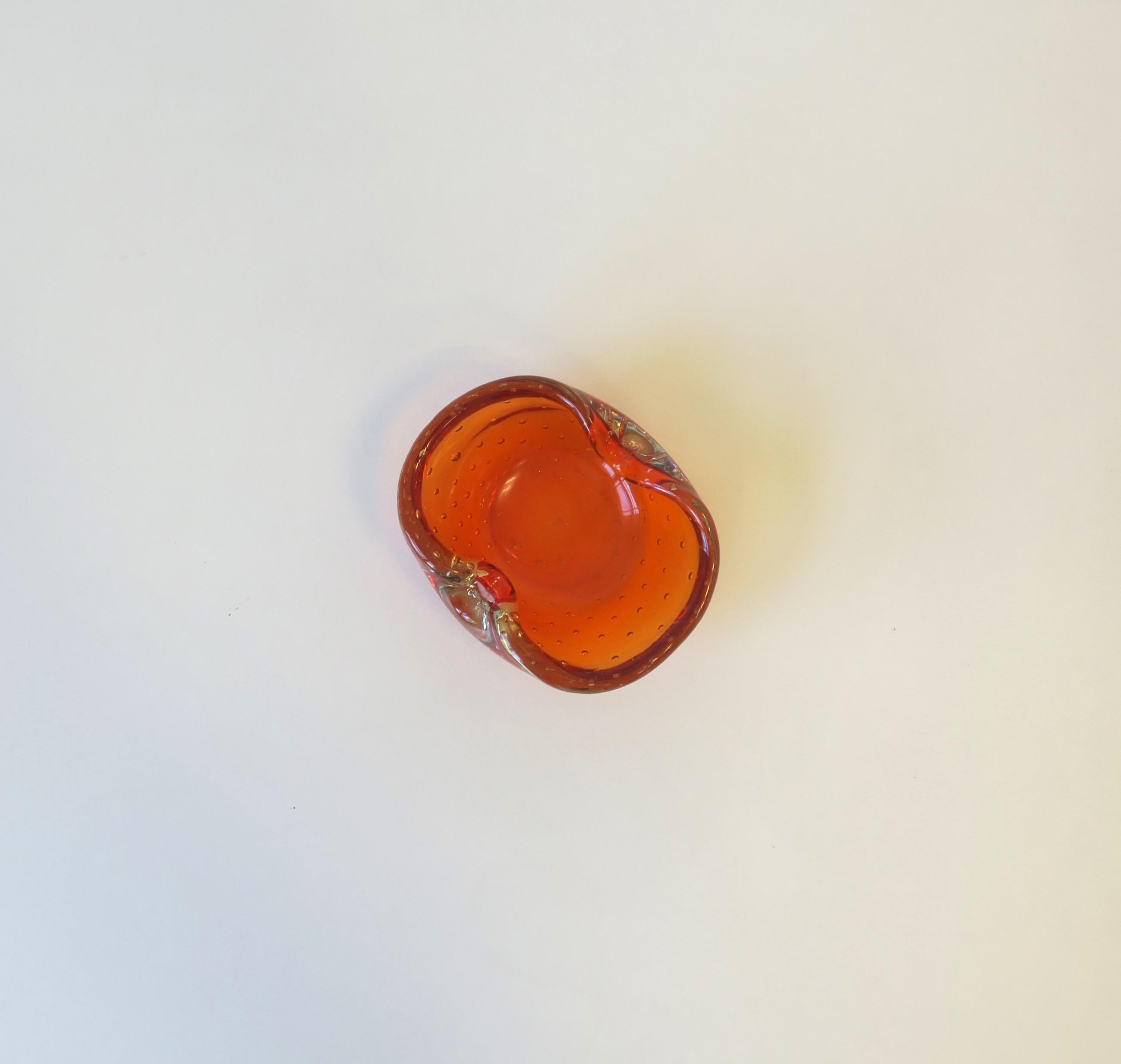 A vintage Italian Murano orange art glass bowl in the Venini Seguso style, circa mid-20th century, Italy. Piece is a juicy orange hue with a controlled bubble 'bullicante' design. Great as a standalone piece, to hold jewelry on a vanity, office