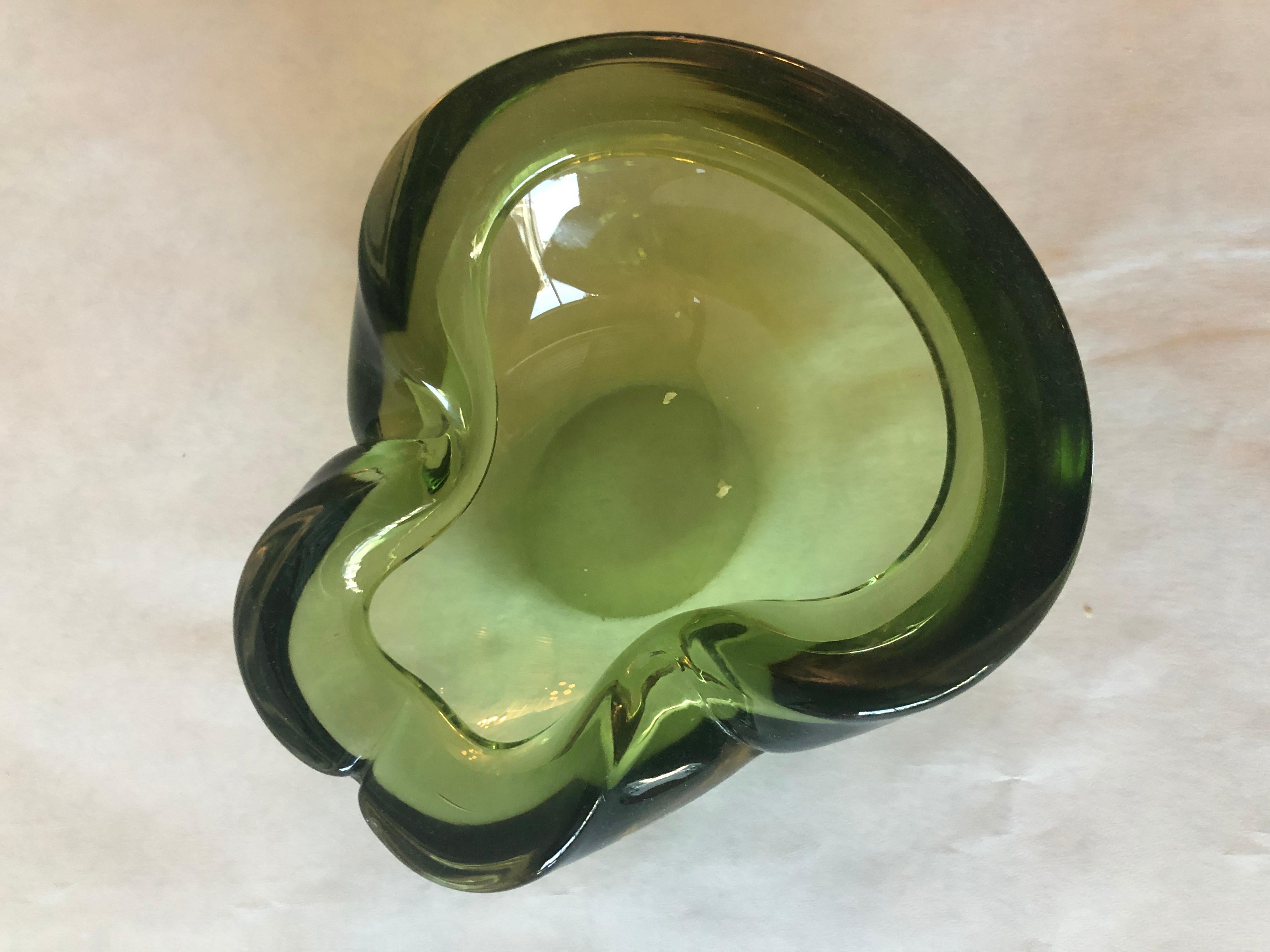 In offerta c'è un posacenere/caramellaio/oggetto decorativo in vetro soffiato italiano di Murano, di colore verde peridoto, risalente alla metà del secolo scorso. Le onde di questa ciotola e le variazioni del verde del peridoto attraverso le onde