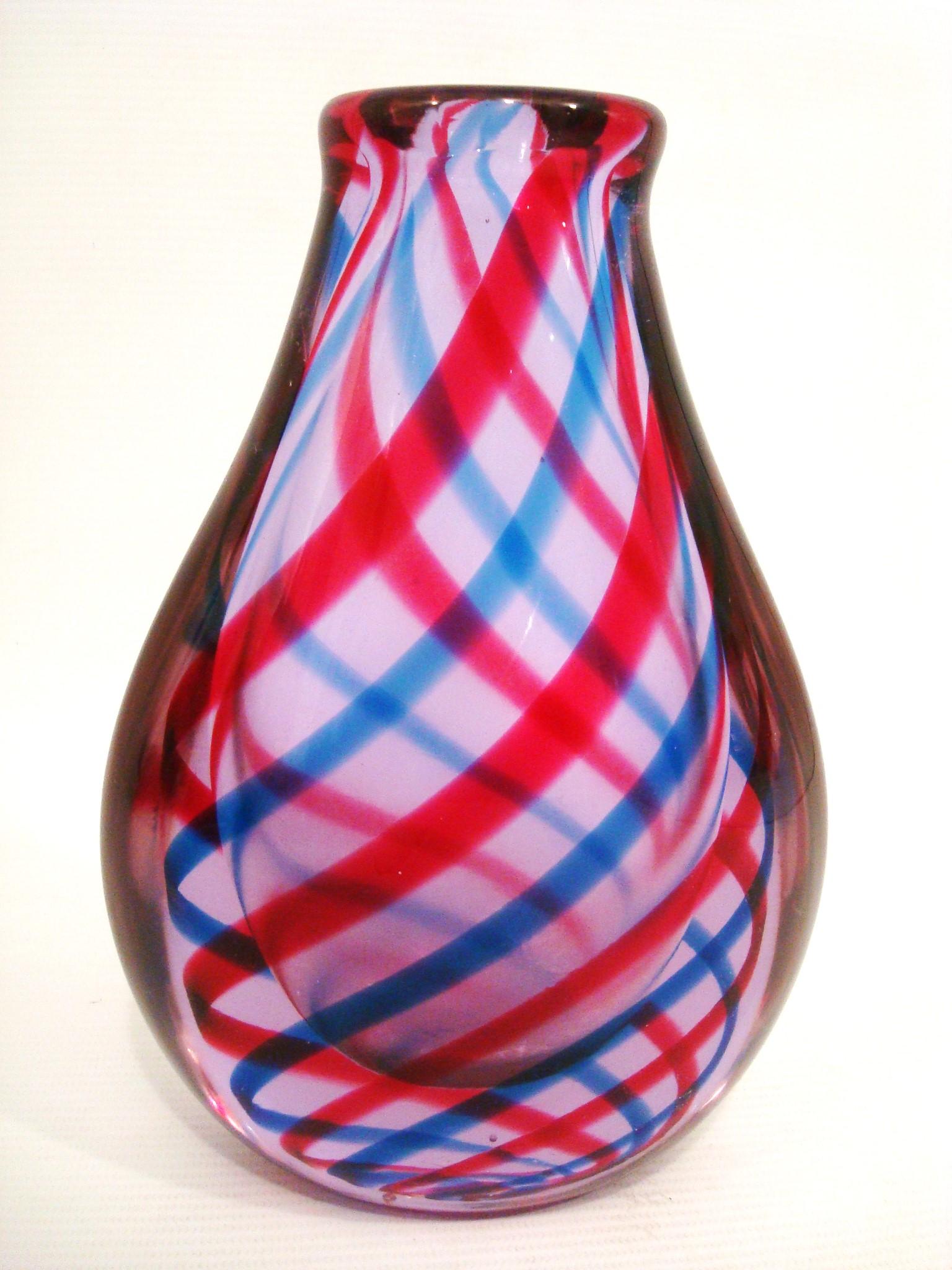 Vaso in vetro artistico soffiato a nastro di Murano attribuito a Barovier&Toso.
Nastro a righe blu e rosse che gira intorno al corpo dall'alto verso il basso.

Un vaso di vetro dalla forma bulbosa e dal collo stretto. Il vaso è caratterizzato da un