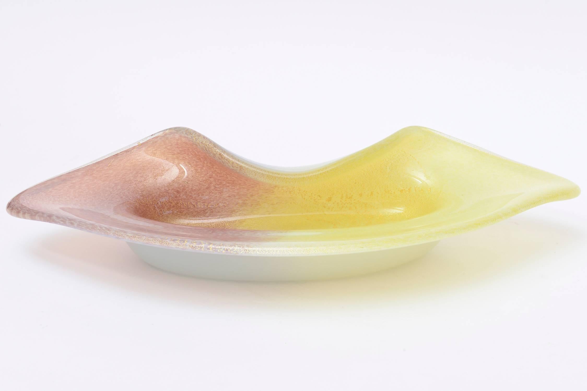 This beautiful folded Italian Murano Seguso cased folded glass bowl is large and Mid-Century Modern. It has the combinations of two colors of light yellow with dusty aubergine purple. The gold aventurine is abundant throughout both colors. The