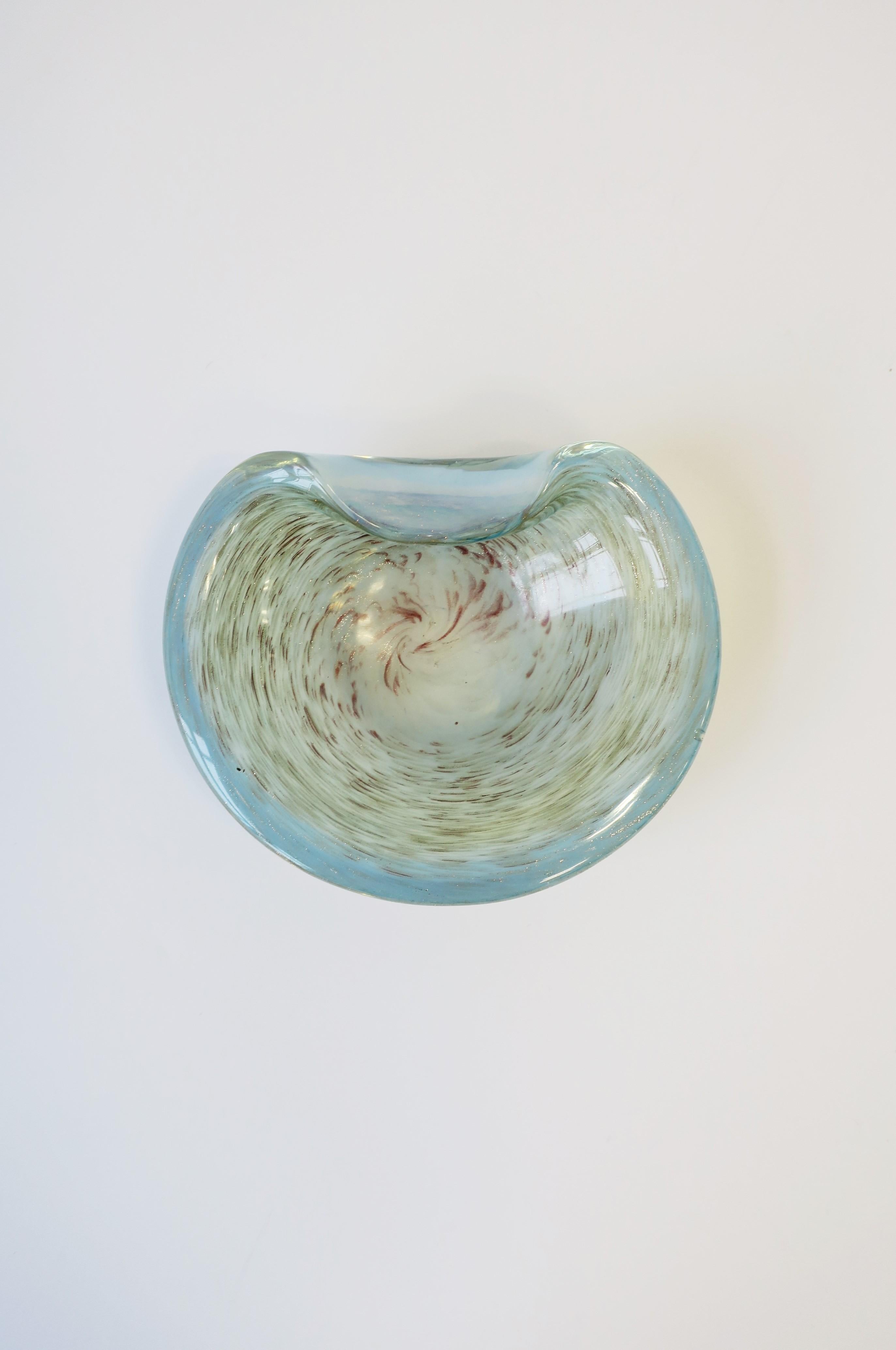 A beautiful Italian Murano shimmering light blue/ice blue art glass bowl with swirls of copper and gold, midcentury modern period, circa 1960s, Italy. Dimensions: 5