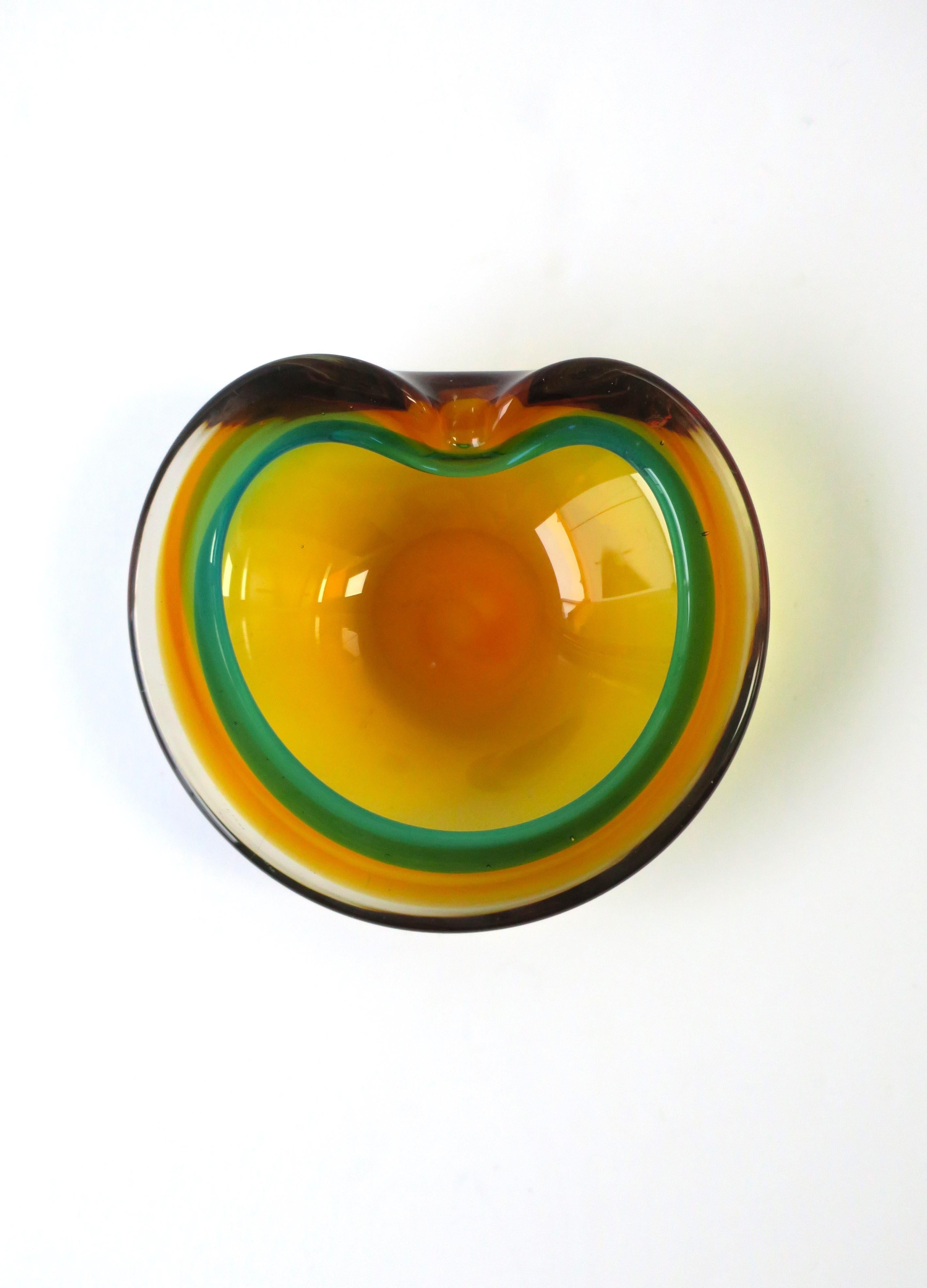 A substantial Italian Murano 'Sommerso' bowl in saffron yellow and Kelly-green art glass attributed to the Seguso atelier, circa mid-20th century, 1960s, Italy. Bowl can also double as an ashtray, with dip/indent allowing room for a cigarette,