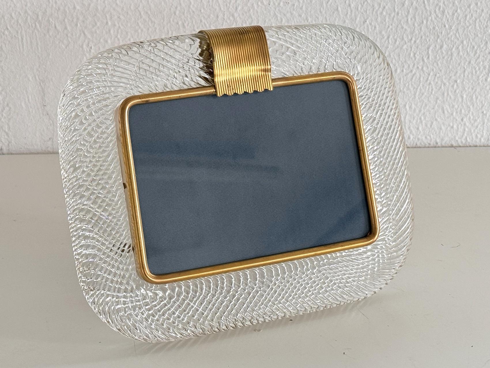 Magnifique cadre photo avec une bordure en verre de Murano clair torsadé, solide et lourd, fabriqué à la main.
La photo est protégée à l'intérieur par une vitre. 
Le dos peut être facilement retiré à l'aide d'un petit tournevis cruciforme pour y