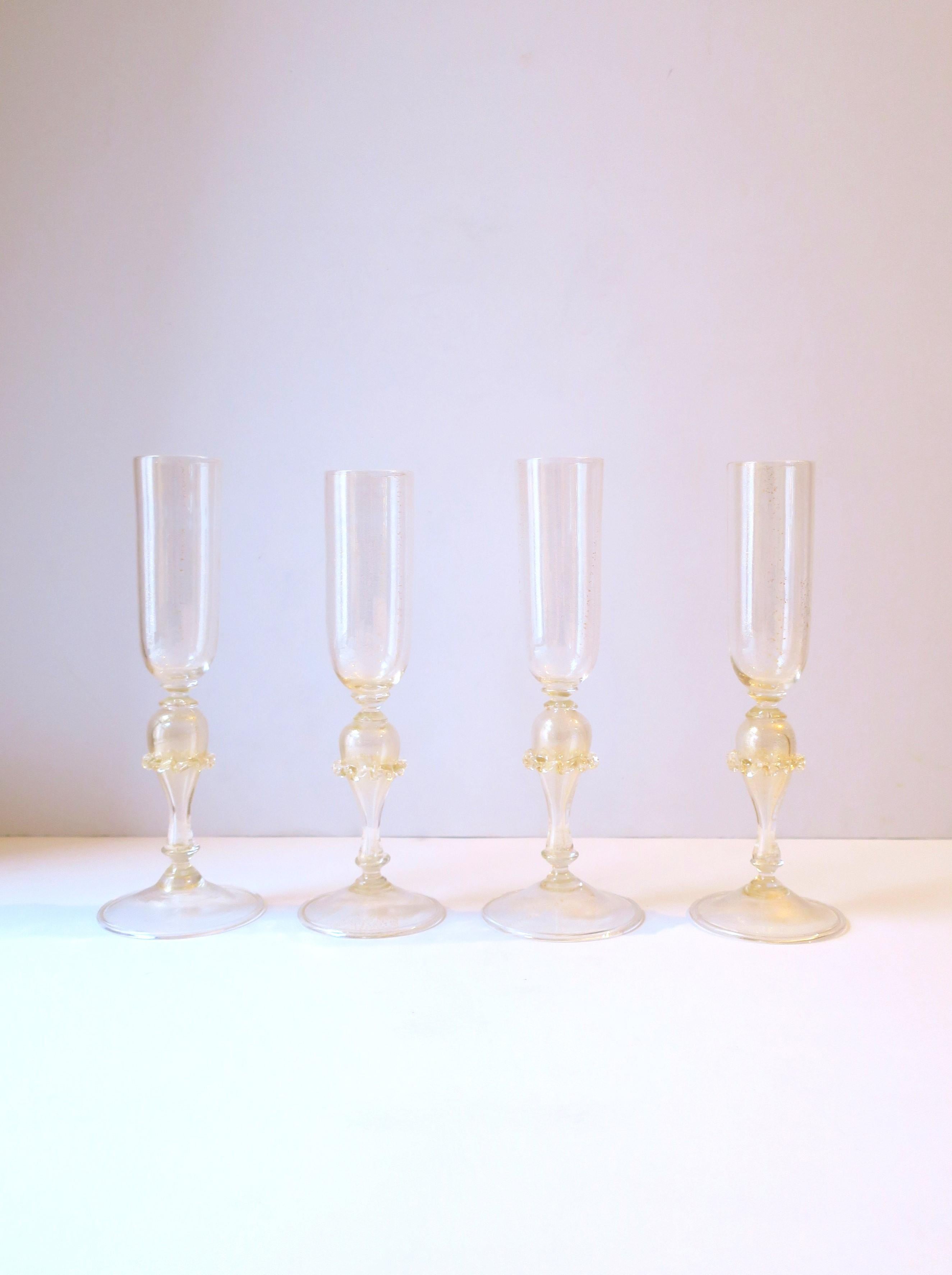 A very beautiful set of four (4) hand-made, hand-blown, Italian Venetian Murano gold and transparent art glass Champagne flute glasses, circa late-20th century, Italy. Enjoy Champagne, Champagne cocktail, other cocktails, etc., with this beautiful