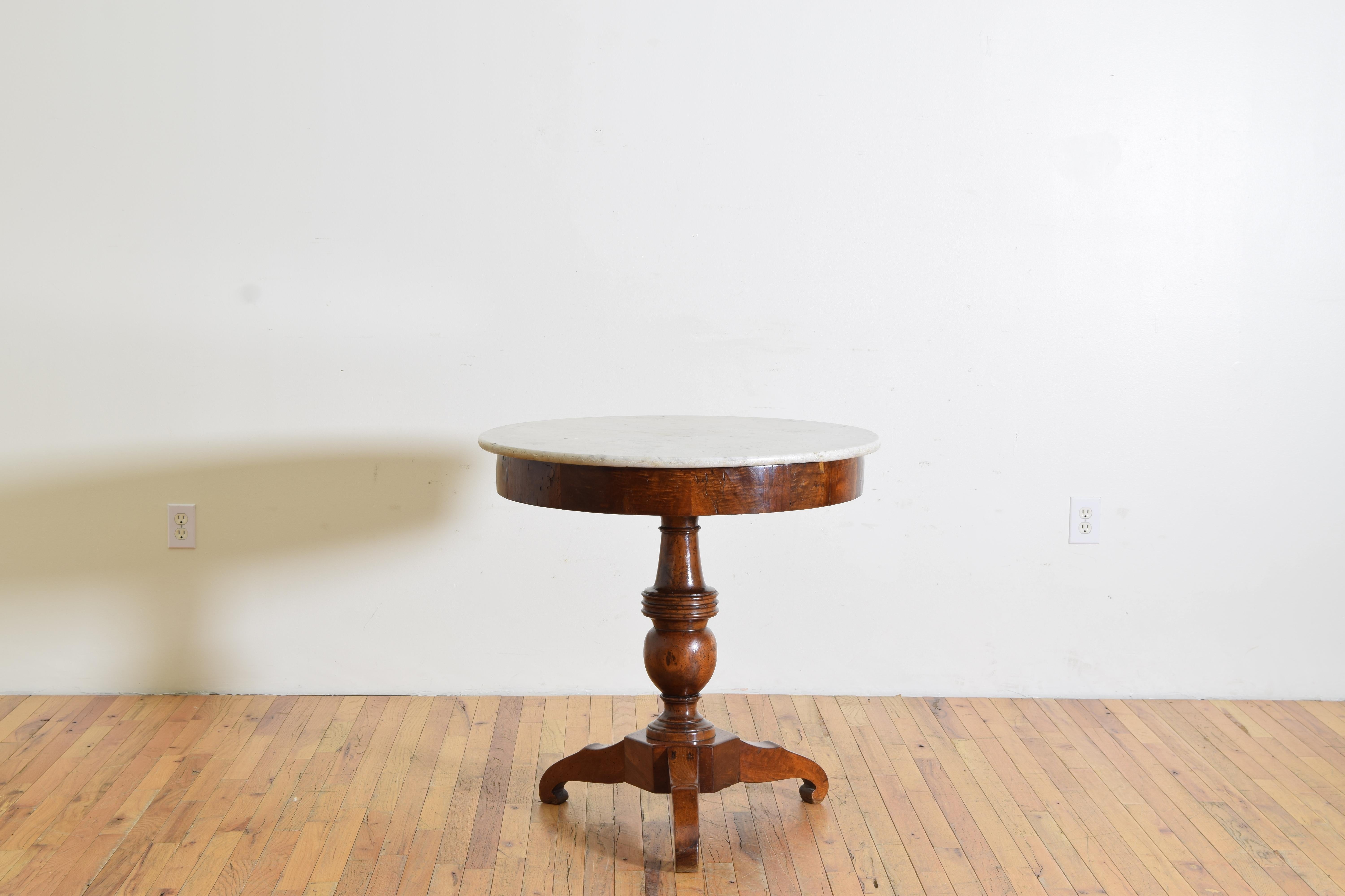 Having its original circular Carrara marble top above a conforming frame with veneered apron atop a solid walnut expertly turned standard resting on a hexagonal base issuing three shaped legs, the base and legs also of solid walnut