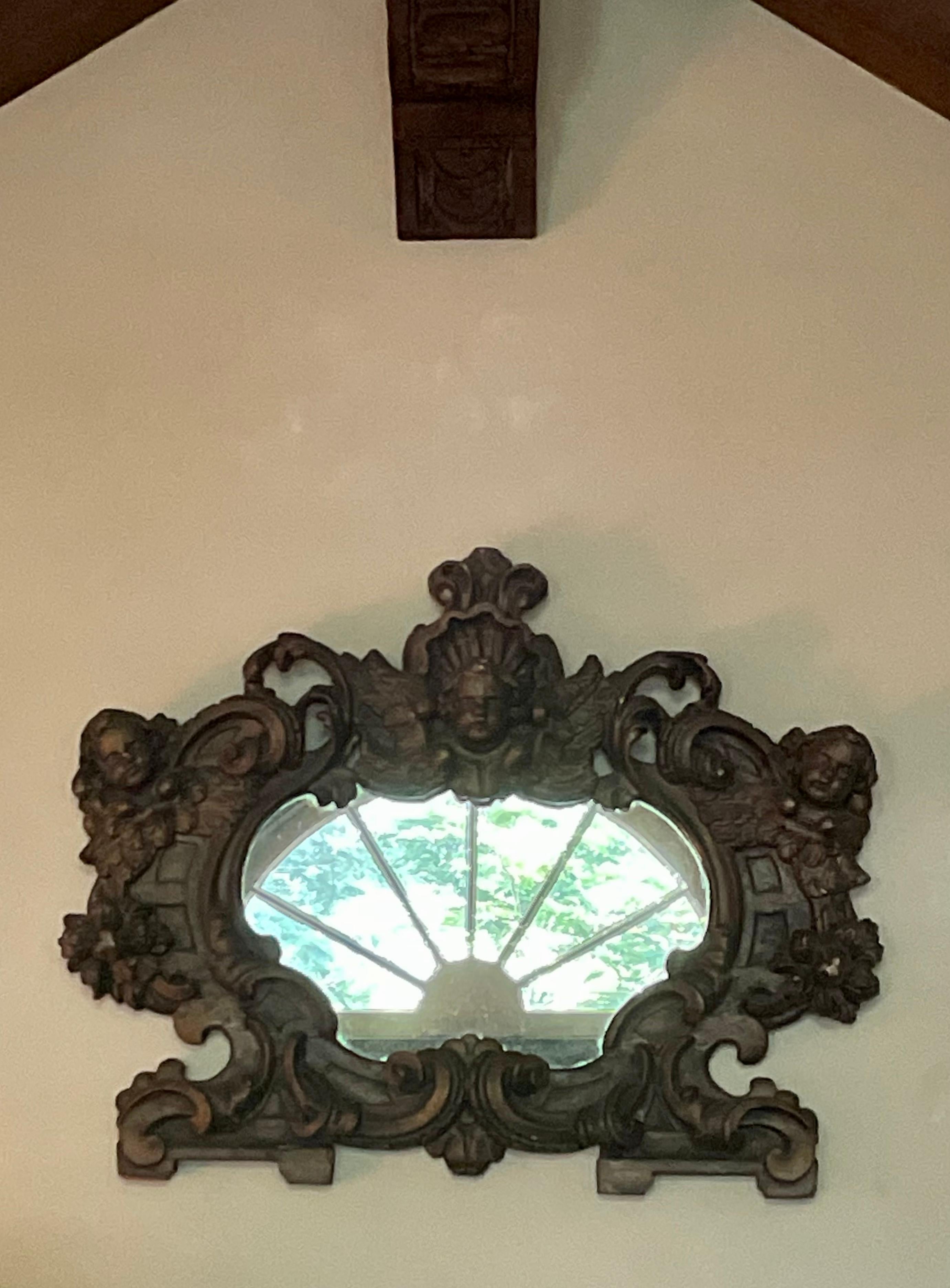 Italian Neo-Baroque mirror. Baroque style mirror with scrolling cartouche frame with putti. Perfect above an entry or in a grouping. 
Dimensions: 24” W x 20” H x 4” Deep.