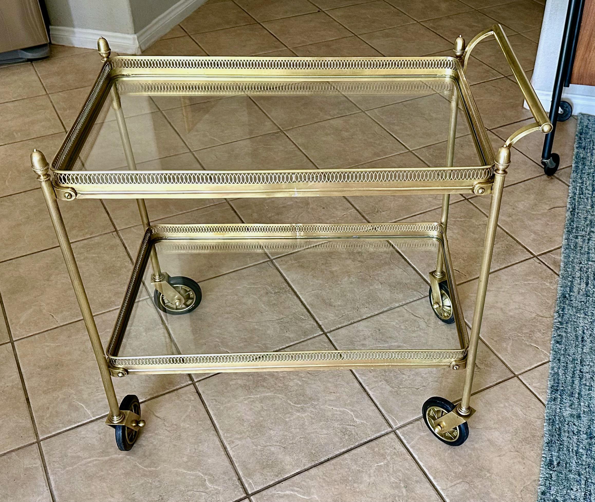 Bar (ou chariot à thé) à 2 niveaux en laiton véritable (non plaqué) de style néoclassique italien. Il présente de belles lignes épurées, avec des rails de galerie percés et des roues pivotantes. Estampillé 