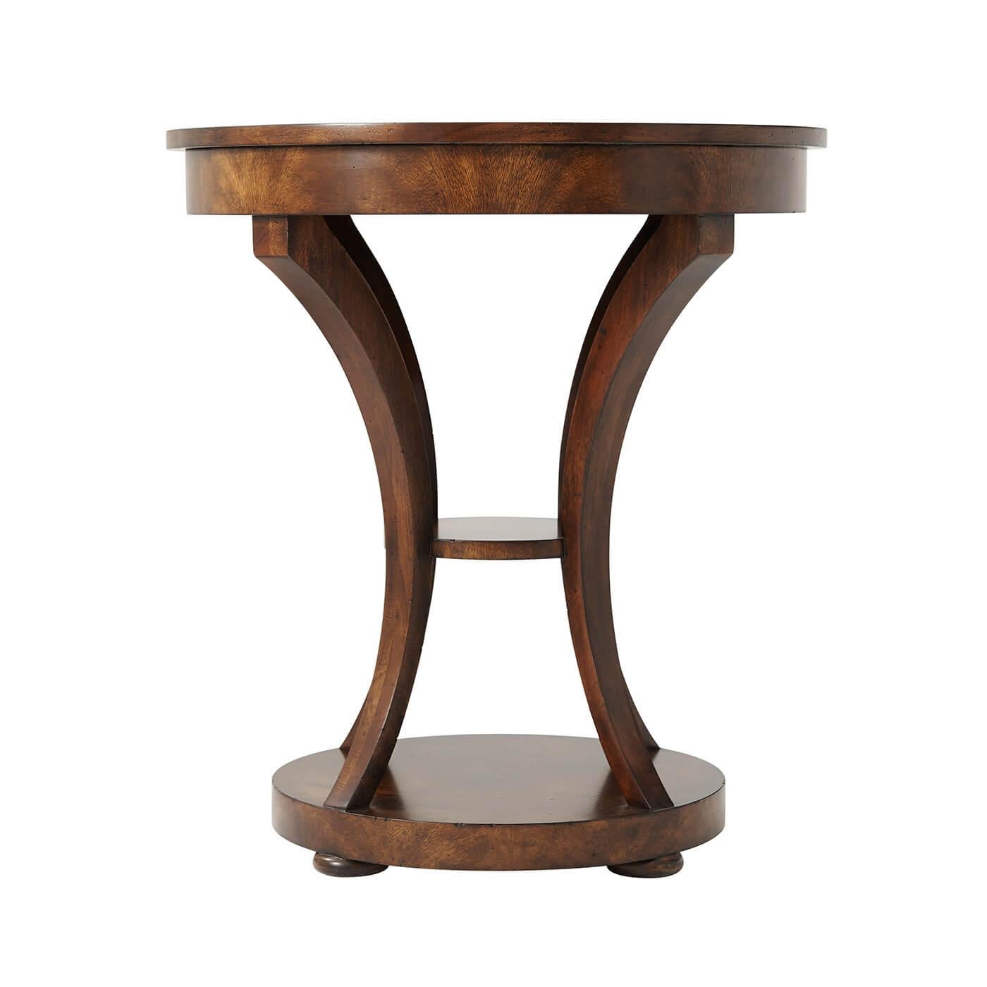 An Italian neo classic mahogany occasional table, the circular crossbanded top above a plain apron and sabre legs joined by an under tier, on a circular platform base and disc feet.

Dimensions: 26