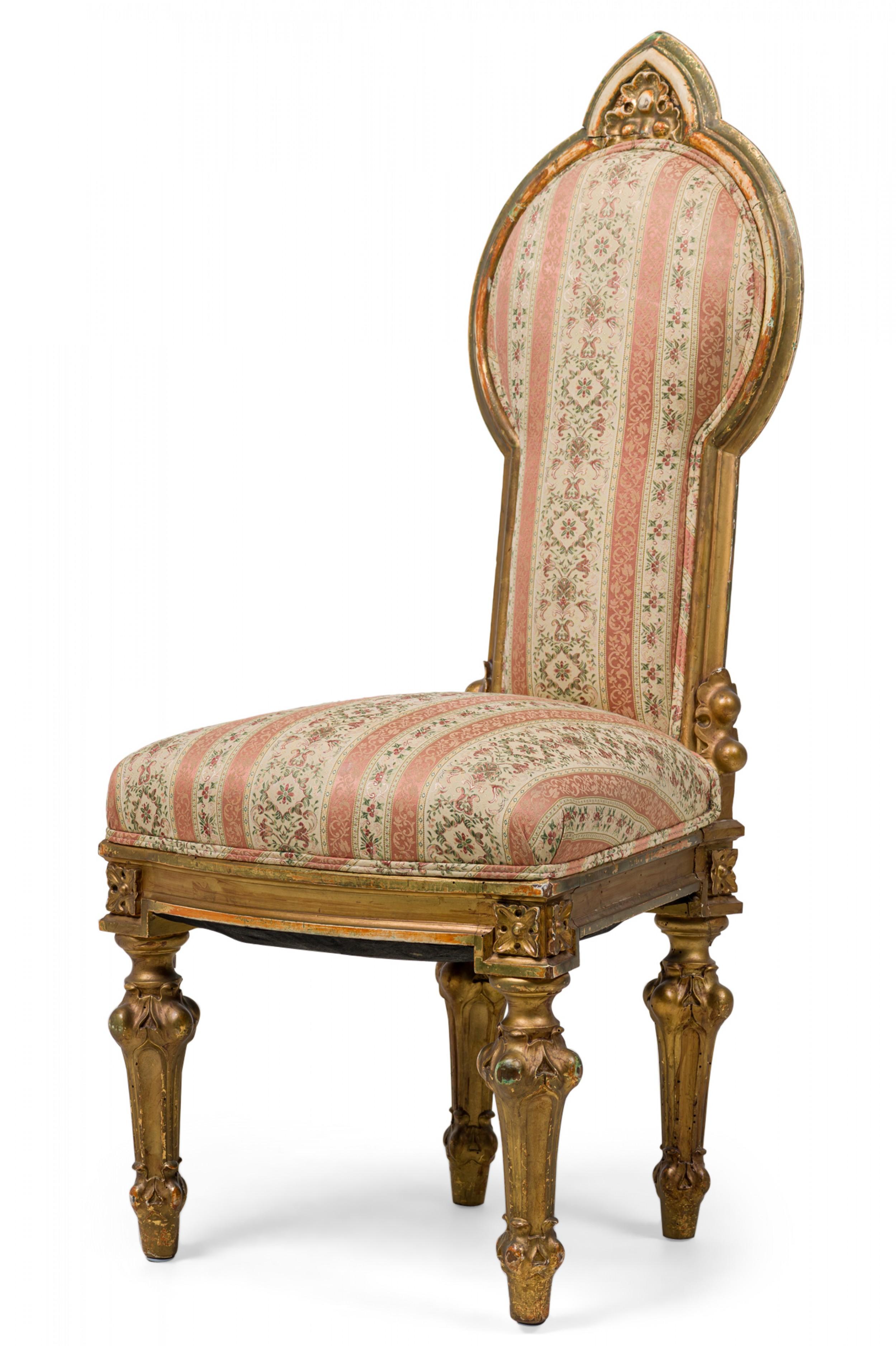 Italian Neo-Classic (18th Century) giltwood dining / side chair featuring a compound shaped oval back, carved foliate crest, ornate painted frame with decorative embellishments, padded back and seat upholstered in a floral stripe pink and beige