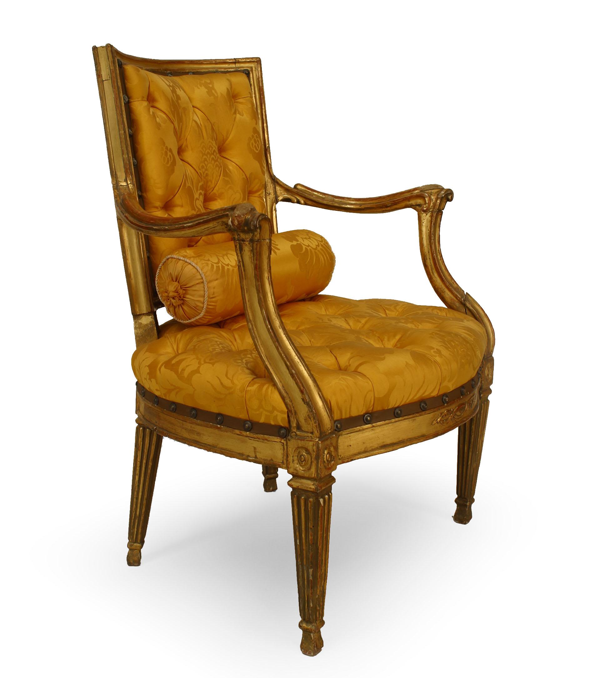Pair of Italian neoclassic (Neopolitan 18th century) open arm chairs with square fluted tapered legs and carving on back rail with gold upholstered seat and back.