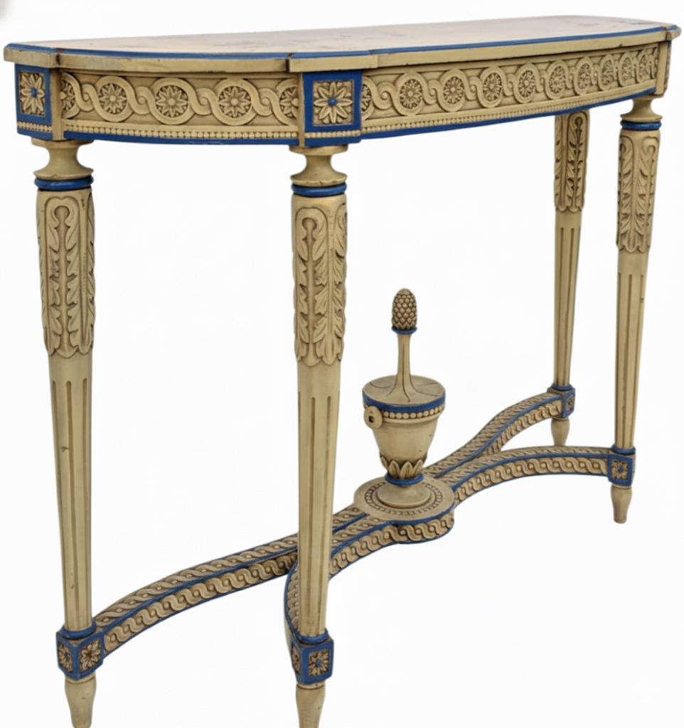 This is a pair of Italian carved and painted Neo-classical style console tables. They are ivory with French blue accents. They date to the 1970s and are in very good condition. Both of these Maison Jansen inspired tables are unmarked.