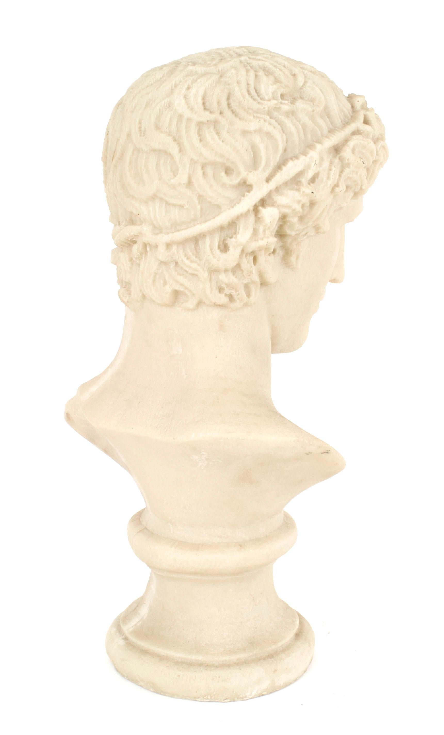 Buste grandeur nature en résine de style néoclassique italien (20e siècle) représentant un jeune Grec ou Romain aux cheveux bouclés, monté sur un socle rond.