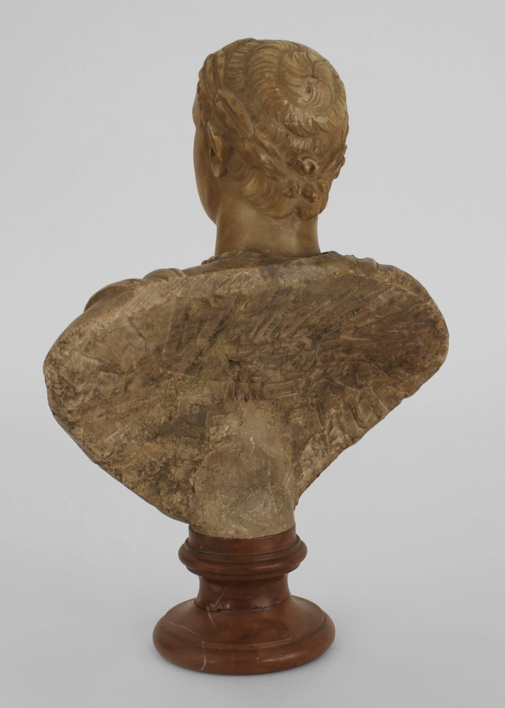 Busto in marmo marrone chiaro di un imperatore romano in stile neoclassico italiano (XIX secolo) montato su un basamento rotondo.
 