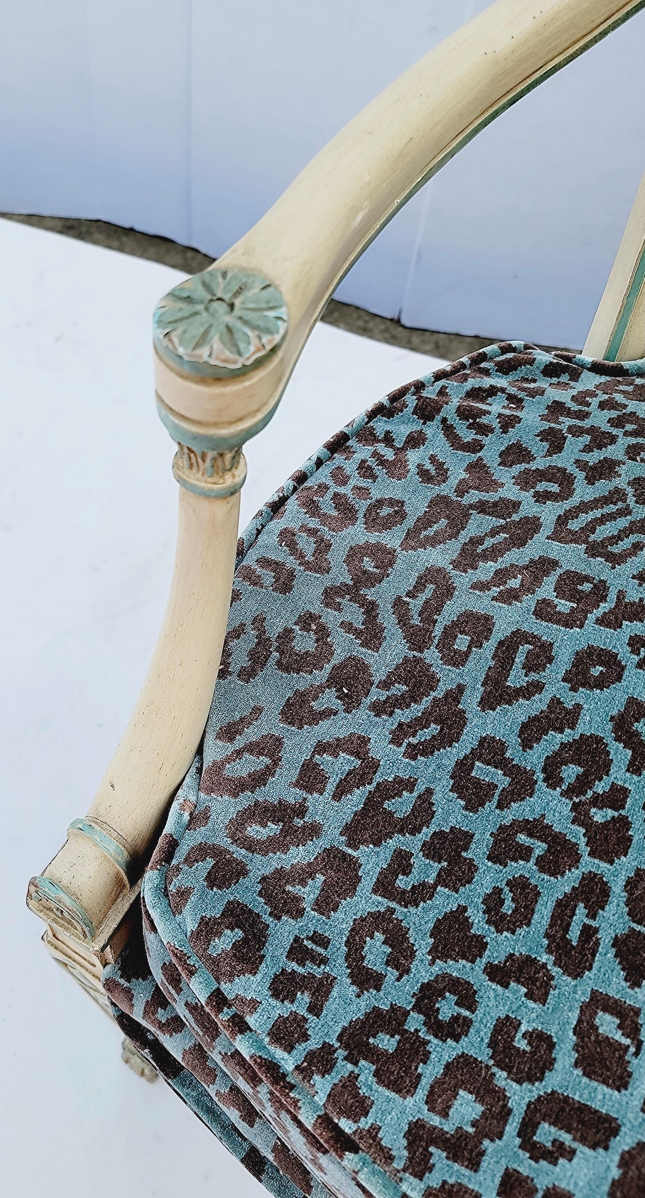 This is a Italian neoclassical style carved bergère chair. The frame is painted ivory with turquoise contrasting color. The leopard velvet is recent.