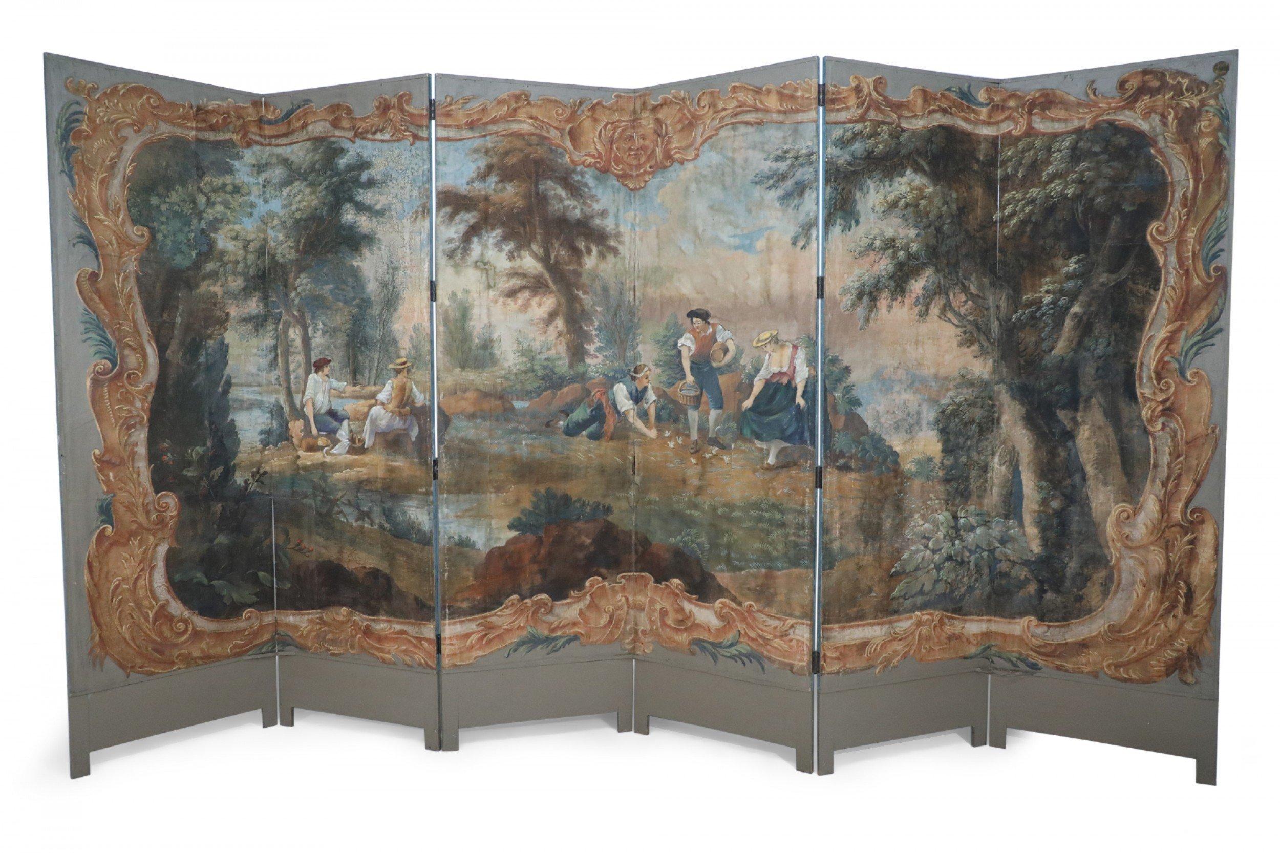 Antique Italian neo-classical-style six-paneled canvas folding screen connected with brass hinges and painted with a vignette of figures at a river's edge surrounded by a painted, ornately-carved golden frame.
        
