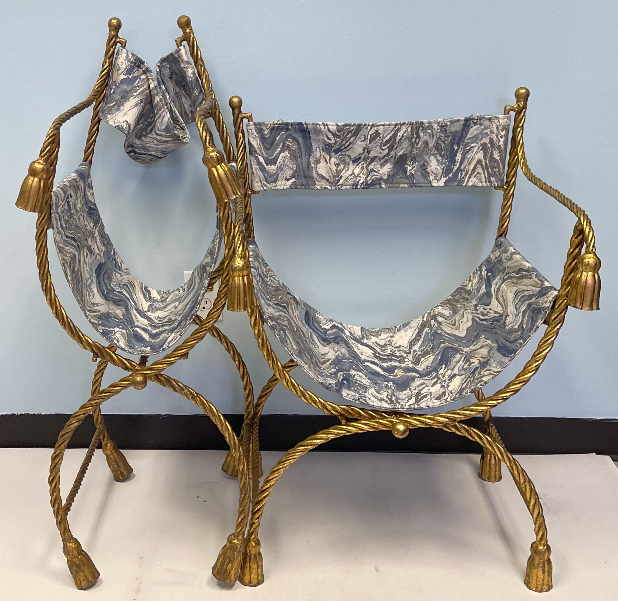 This is a pair of Italian neo-classical style gilt metal tassel Savonarola or campaign chairs. They date to the 60s and the marbleized upholstery is new. Arm; 27.5”. They are amazing!