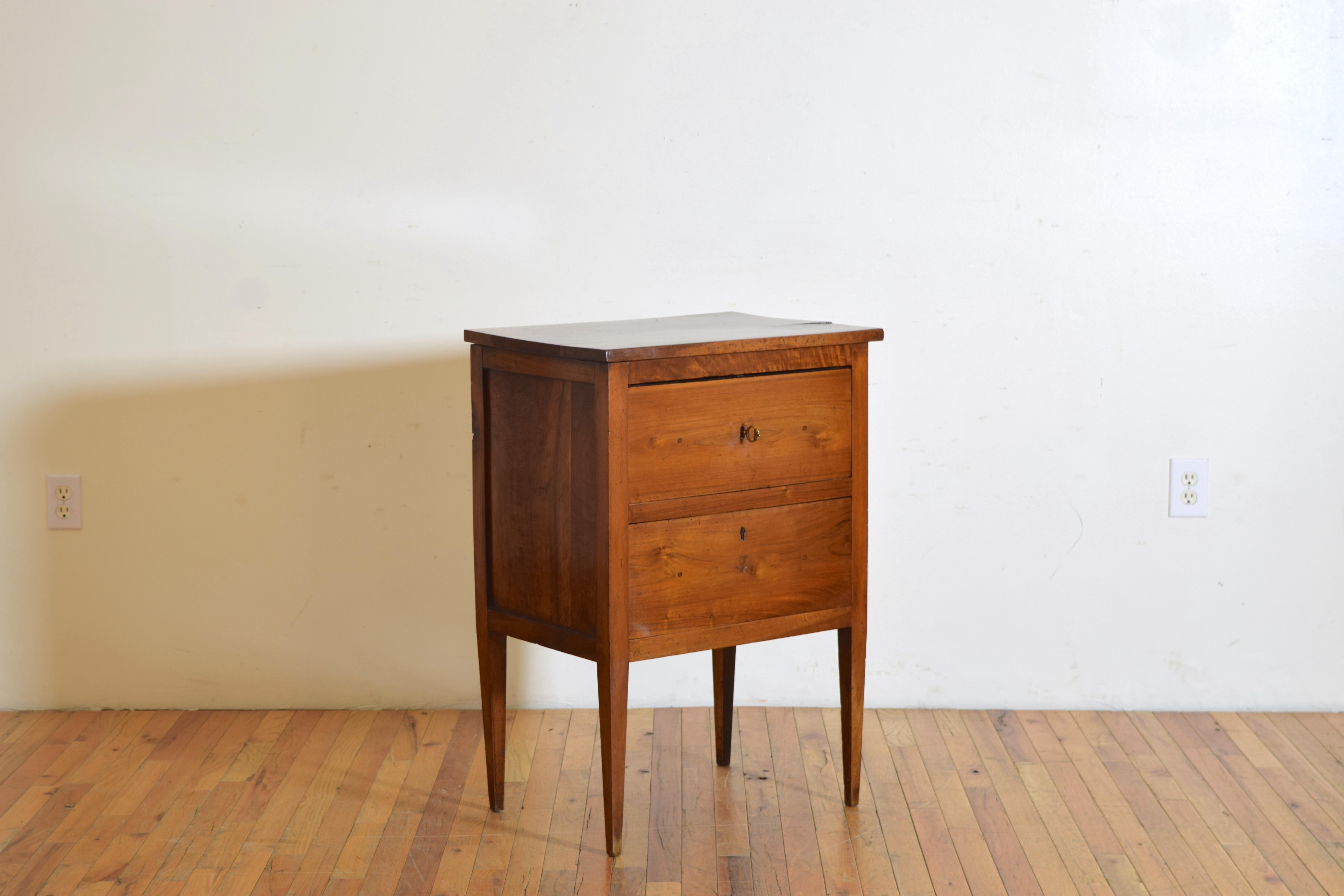 having a rectangular top atop a conforming case housing two drawers, the drawers lined in velvet and having movable upper trays, raised on square tapering legs