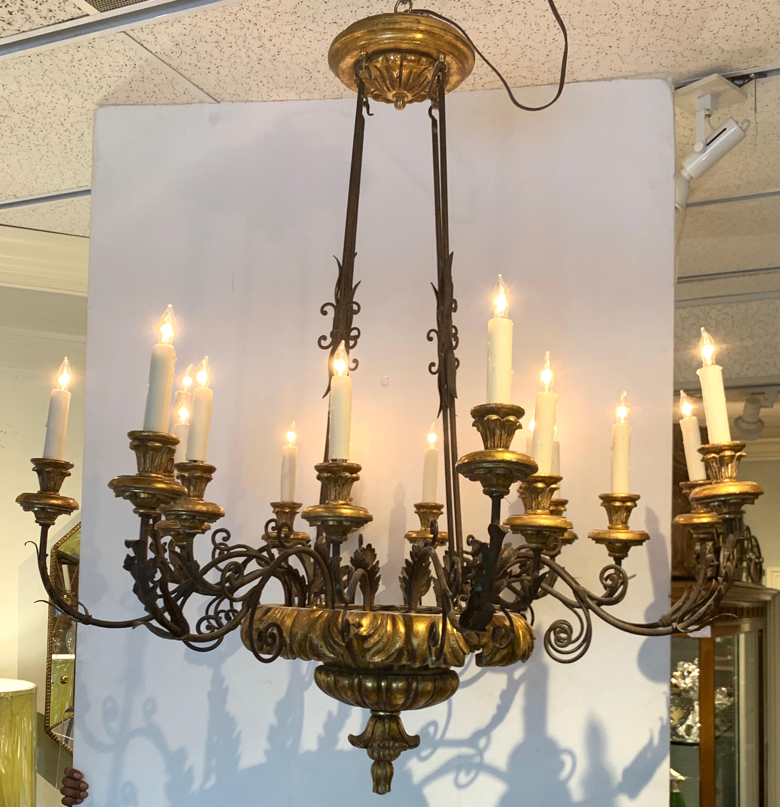 Italian neoclassic carved giltwood and iron 18-light chandelier, of circular form fitted with 18 candelabra bulbs. Great size and scale.