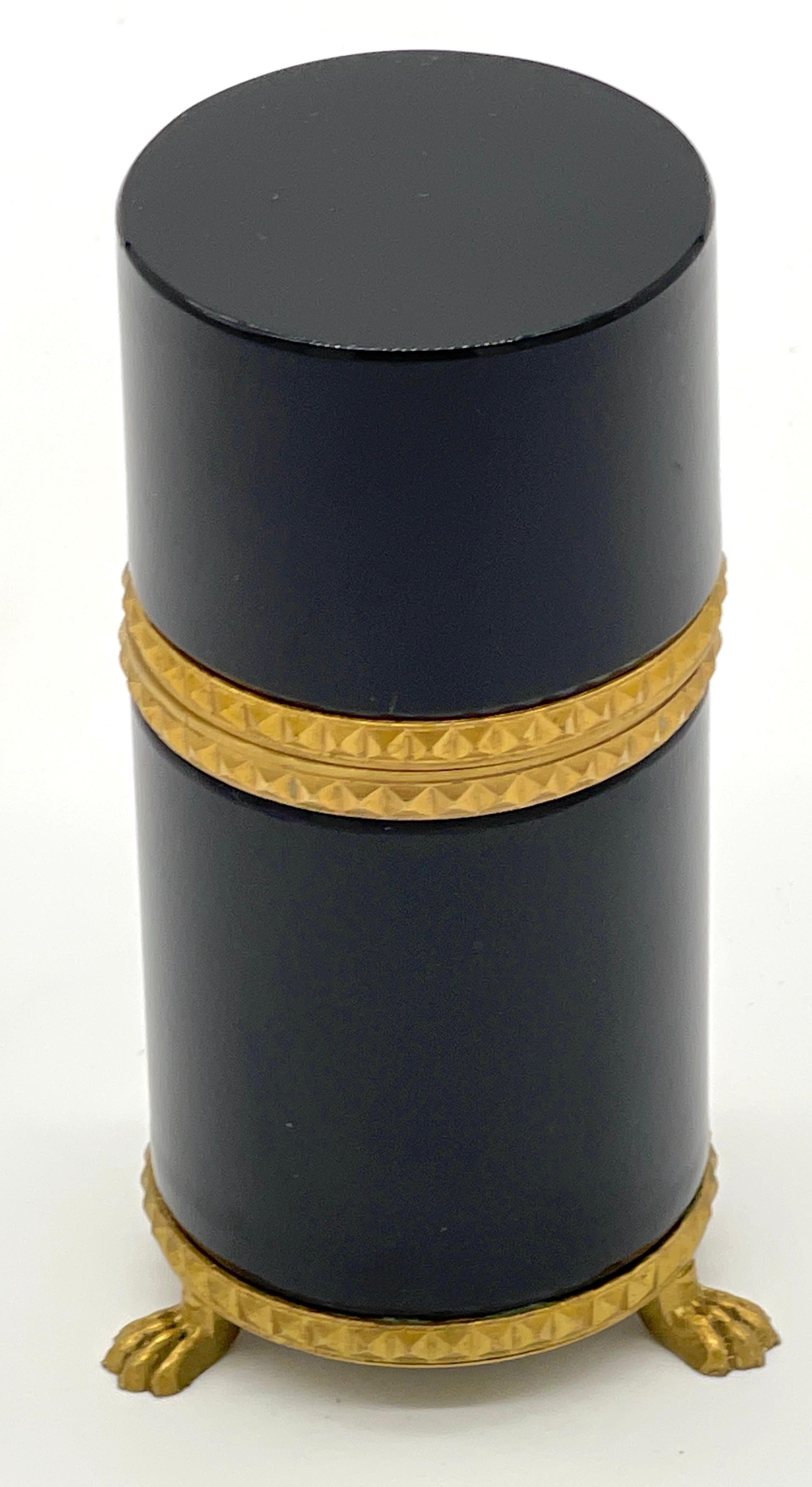 Italian Neoclassic Gilt Bronze Mounted  Black Murano Glass Tall Cylinder Box
Italy, 1960s

A sleek and unique piece from the 1960s, this Italian Neoclassic tall cylinder box is a stunning example of craftsmanship and design. The box is executed in