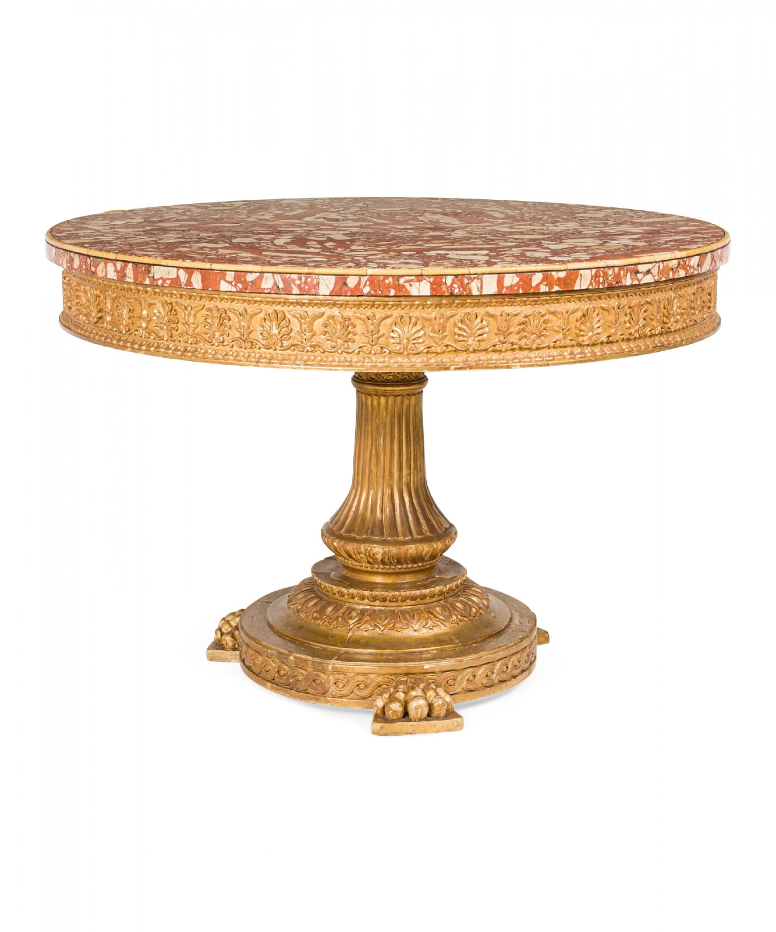 Italian Neoclassic (19th Century) gilt wood center table with an ornately carved giltwood pedestal base having a reeded column below an anthemion carved apron supporting a blush breccia rosso table top, resting on carved claw feet.