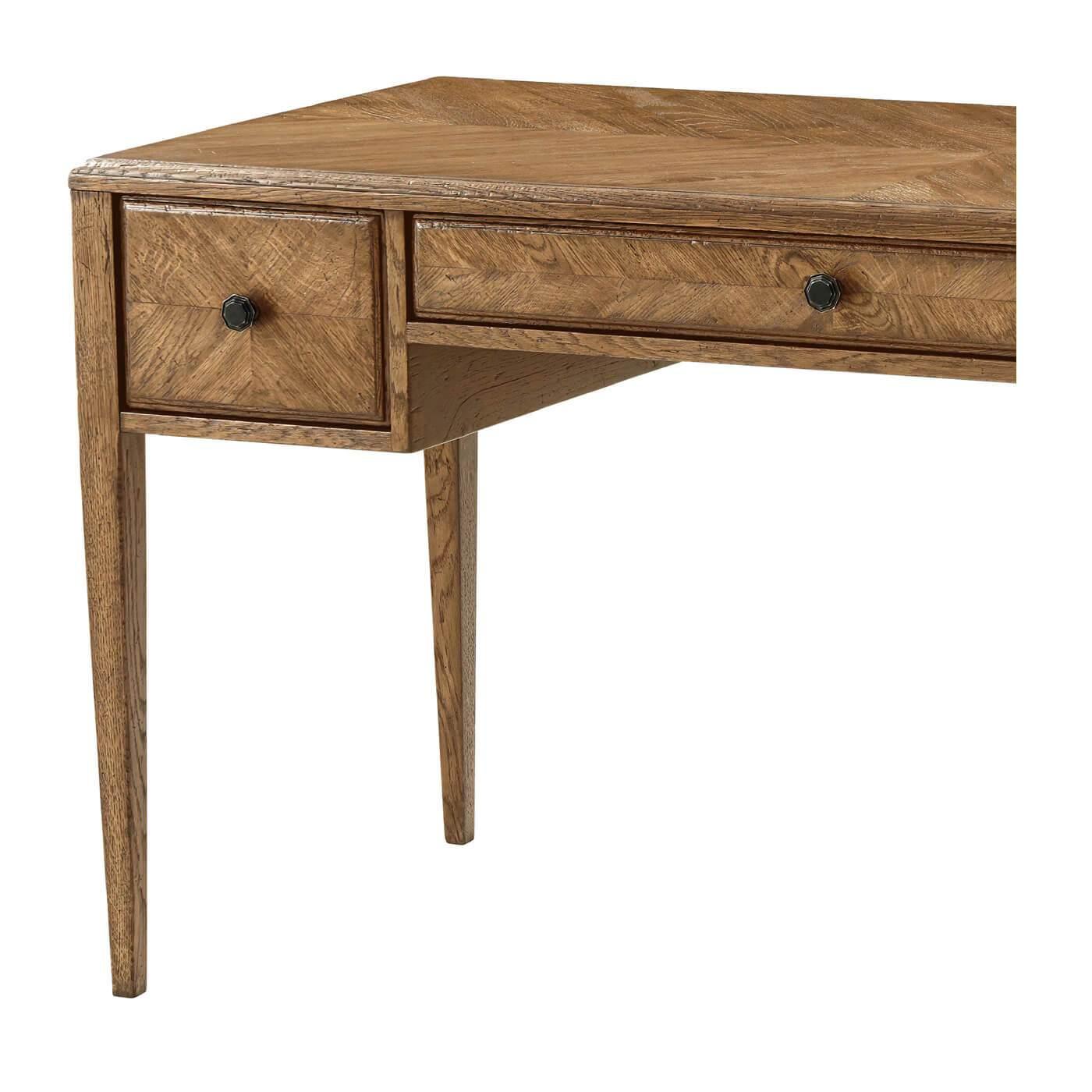 An Italian NeoClassic style starburst pattern parquetry desk with tapered legs. It has one center drawer flanked by two smaller drawers with Verde Bronze finished handles. 
Shown in dawn finish
Dimensions
59.5