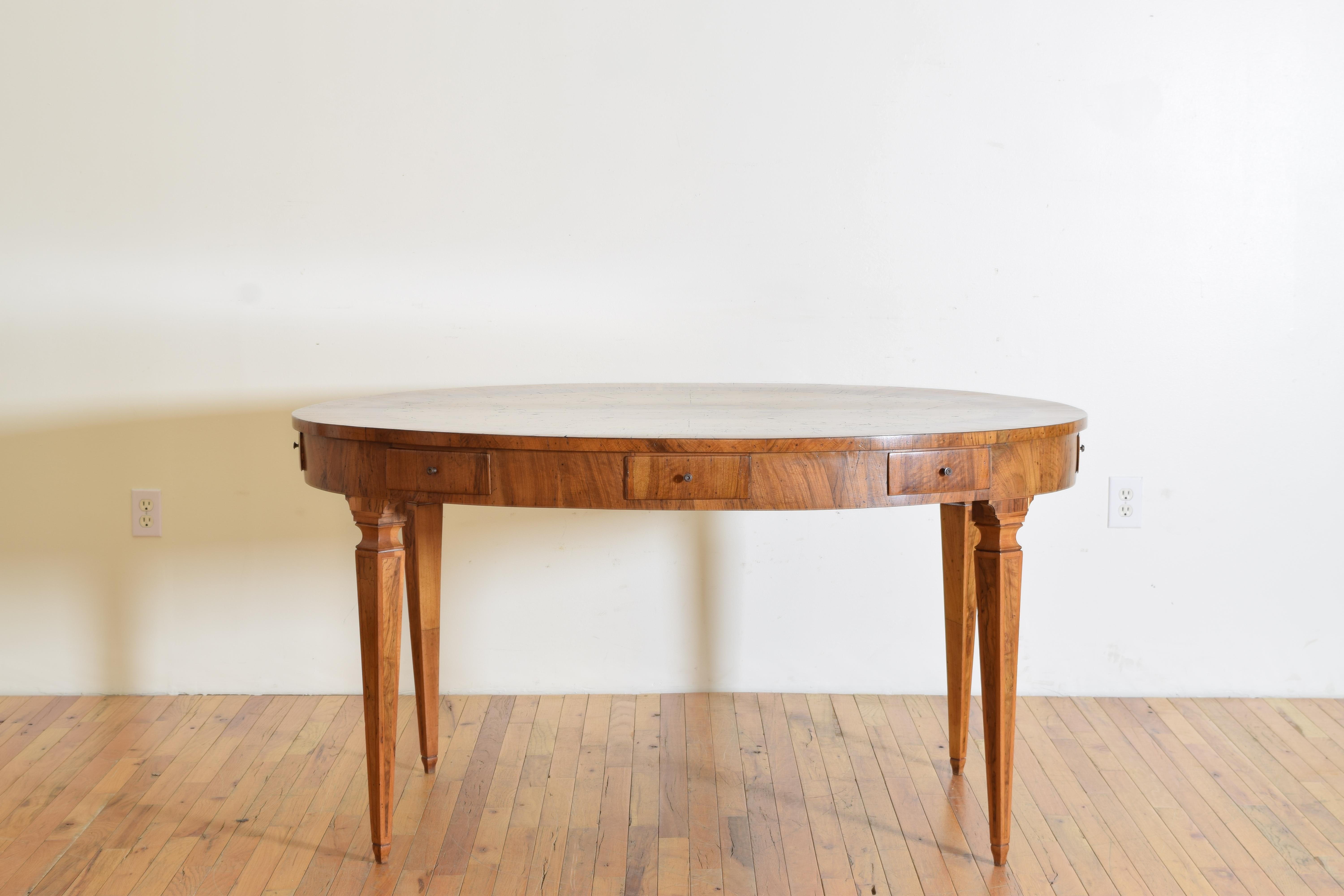 Rare and unique table, oval shaped and covered completely in walnut, fruitwood, and burl walnut veneers with an outer edge of straight walnut veneers, four book matched large burl wood panels, and a centered scroll pattern of fruitwood, the top