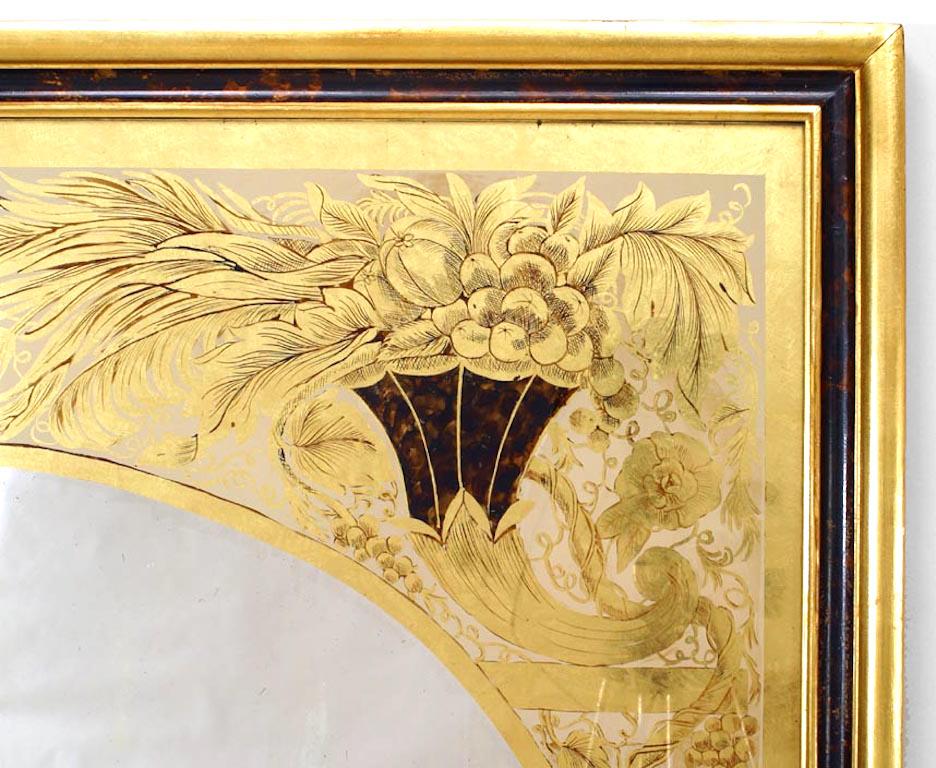 Italian neoclassic style gold Églomisé wall mirror with arched slip decorated with cornucopia and scrolling acanthus vines inside a gilt and faux tortoiseshell frame.
 