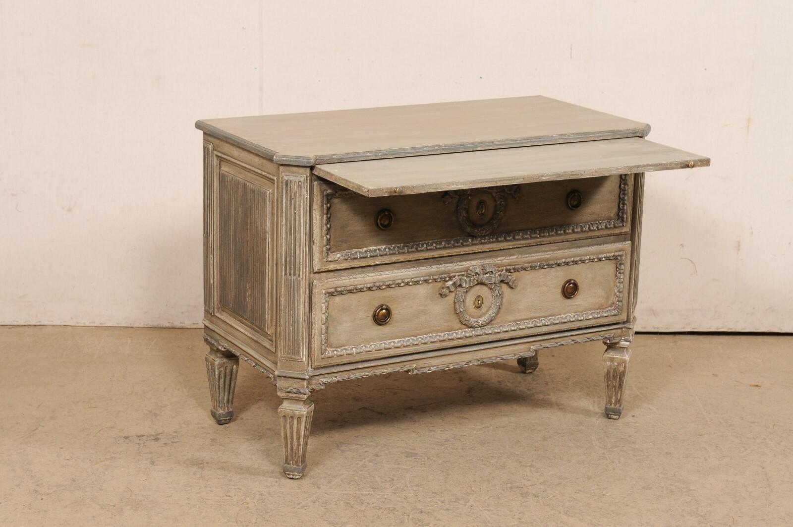 A vintage Neoclassic style painted wood raised chest from Italy. This lovely chest from Italy, circa late 20th century, is a very well made piece with lots of nicely carved details. It has been designed in Neoclassical influences; with canted side