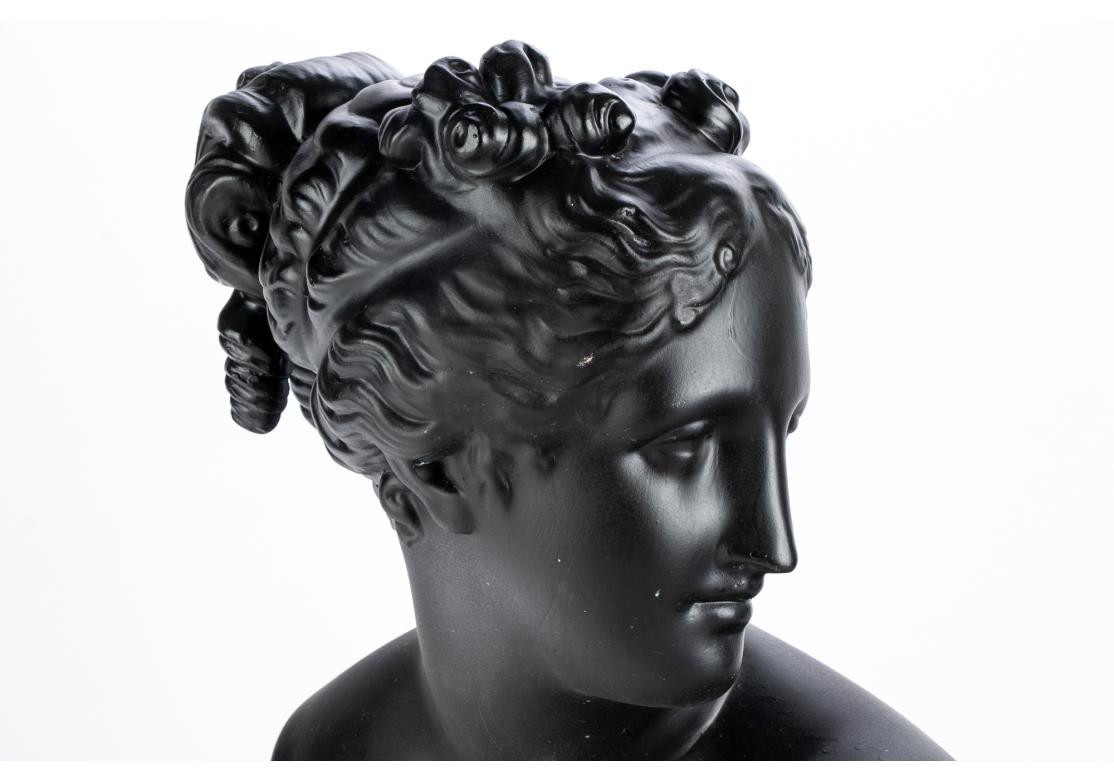 Por VELLUM, Italia. Un busto según una escultura antigua de la diosa con su precioso pelo ondulado recogido y mirando a un lado. En el borde inferior se ve un detalle de su vestido plisado. 
Conserva una pegatina acrílica en la que se lee Vellum,