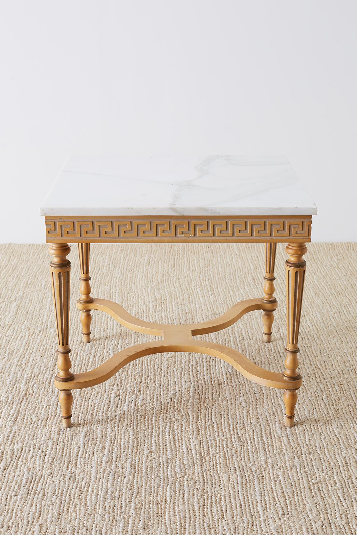 Mid-Century Modern Italian table featuring a 1 inch thick Carrara marble top. Square table made in the neoclassical taste with a decorative Greek key design veneer on the frieze. Supported by four fluted legs conjoined by a cross stretcher and