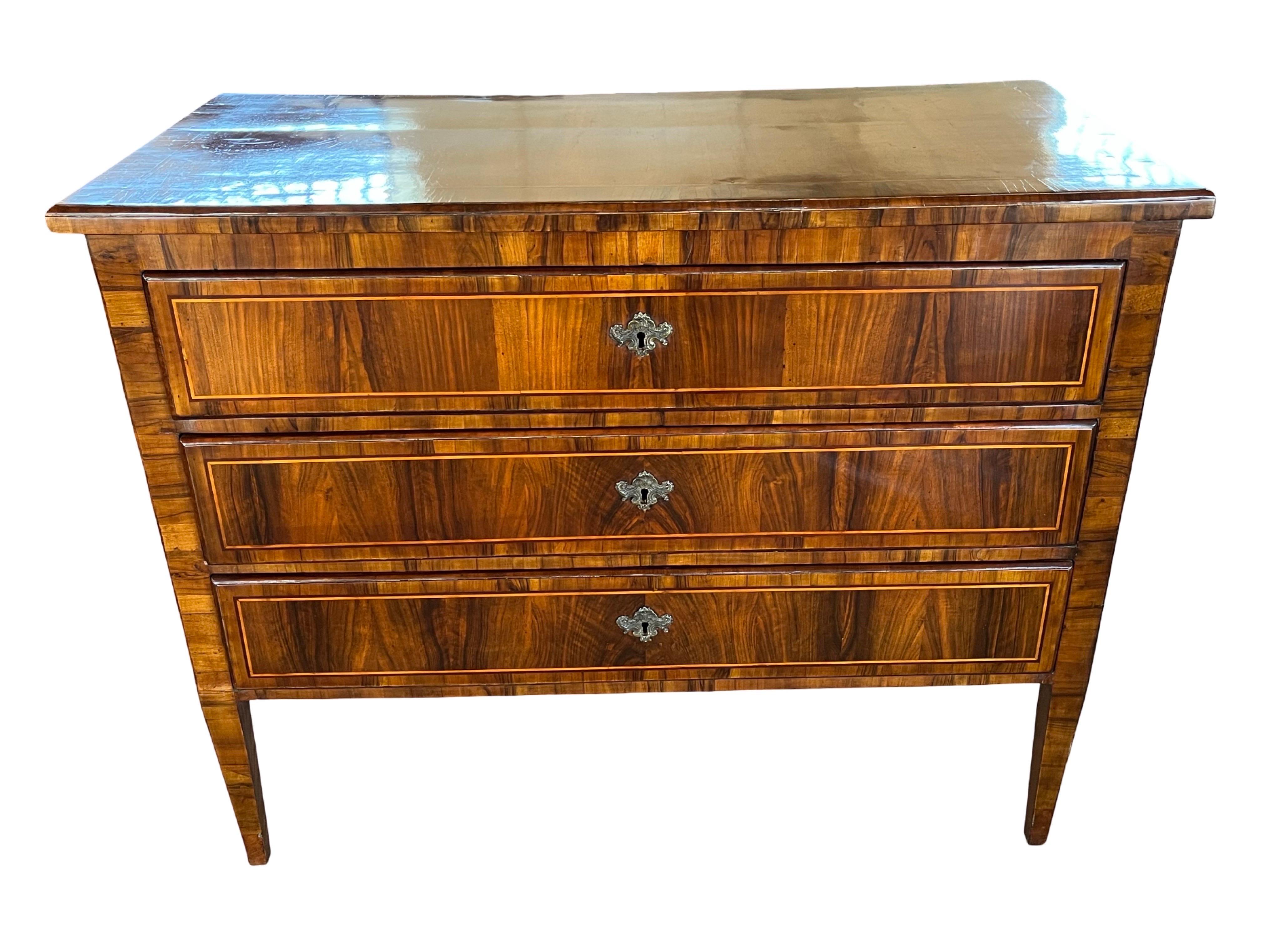 Neoclassical chest of drawers hand-made in Italy in the late 1700s using walnut and decorated with walnut veneer. The chest is very straight in lines, however, the cross-banded veneer and grain of the wood soften the edges and overall look. The