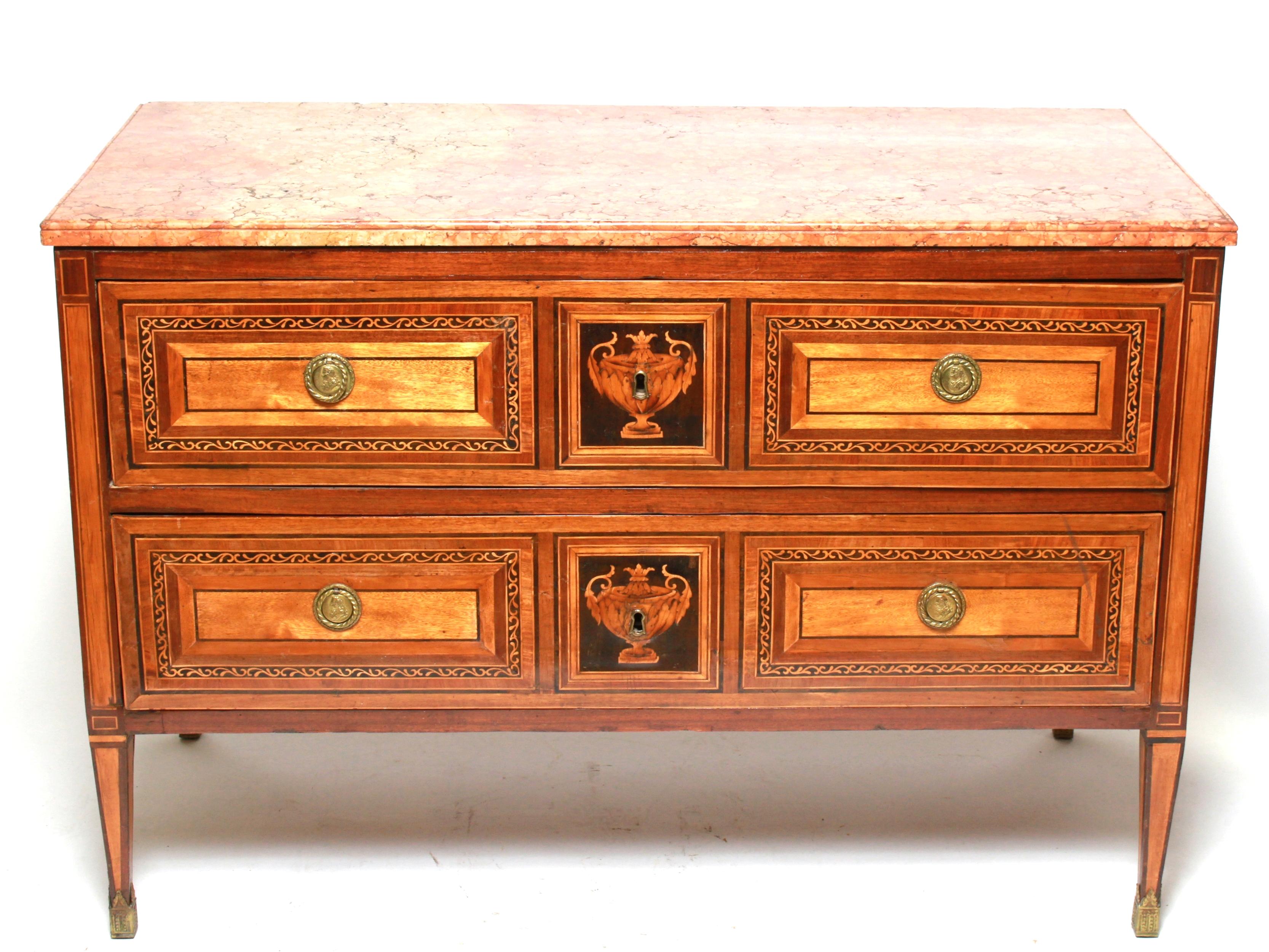 Northern Italian neoclassical pair of commodes with intricate inlay motives of vines and urns, attributed to Italian cabinetmaker Giuseppe Maggiolini. 
The pair was likely made in circa 1800 and has the original antique marble tops. Two large