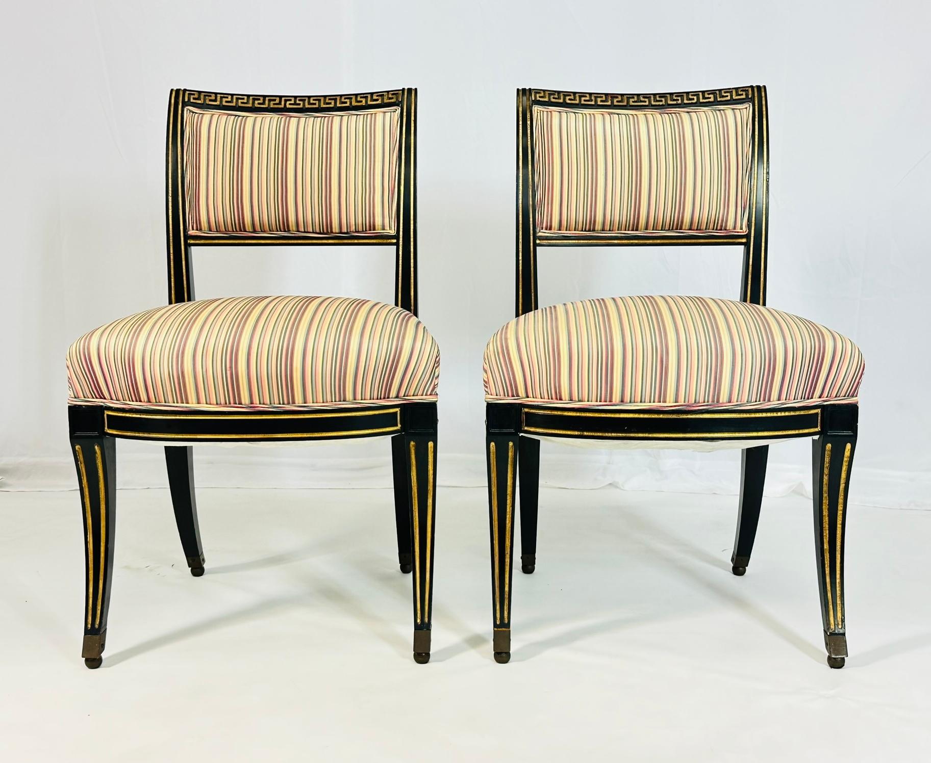Pair of antique slipper chairs with ebonized and parcel gilt wooden frames and upholstered in a silk fabric.

The chairs have beautiful silhouettes, they have sold brass caps on the legs, a Greek design to the top of the backrests and parcel gilt