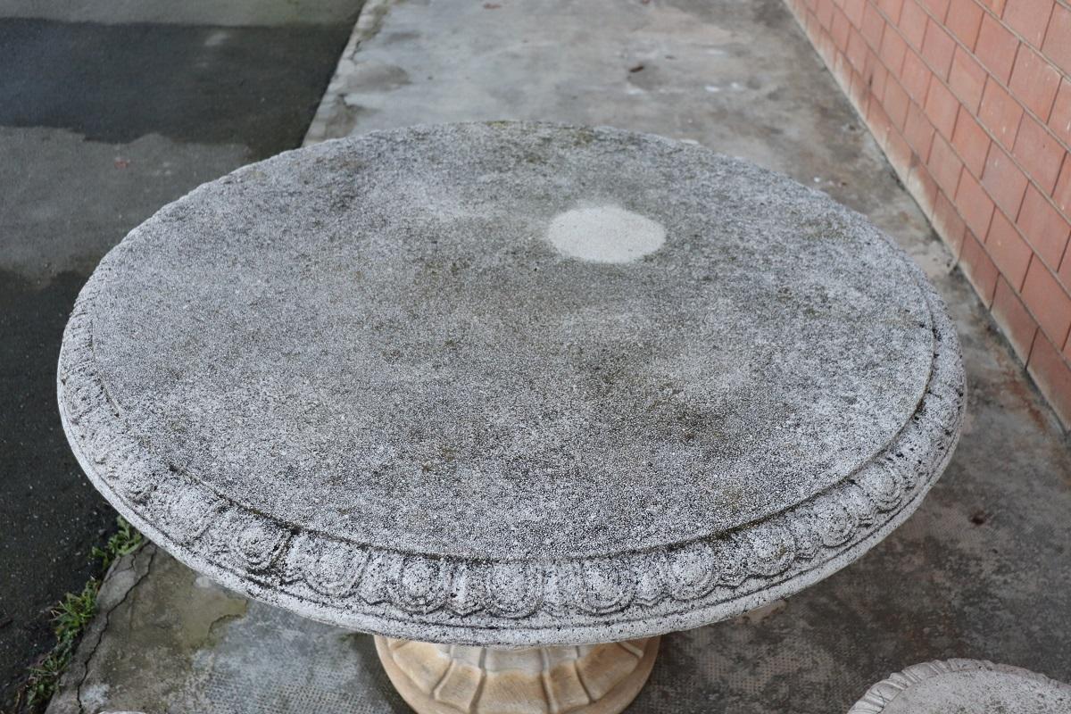Beautiful refined garden set in neoclassical style, circa 1980s main material mixed with gravel and cement. Beautiful round table with four stools. Gorgeous carved decoration. The set shows signs of the passage of time. This garden set is perfect