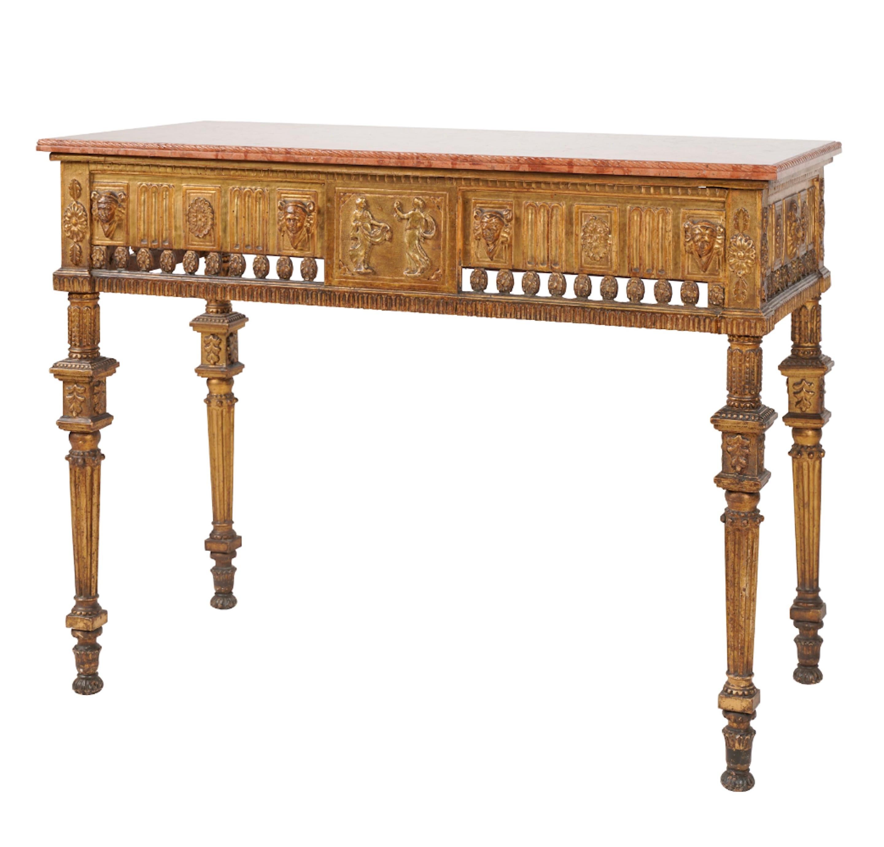 Neoclassical hand carved, gilt wood and rouge marble console.  The marble top has a carved molded edge, the frieze relief is carved with masks and rosettes and a pierced border of rosettes, flanking a central panel with a pair of dancing figures.