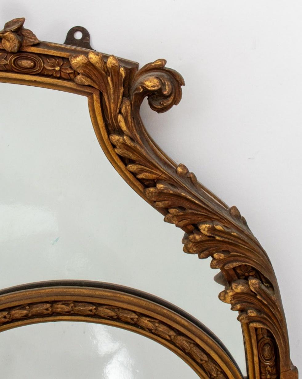 Italian Neoclassical gilt wood mirror, the pediment carved with foliate motifs, surmounted by a bow, and with a ceramic cameo plaque depicting the profile of a female figure on a blue ground, circa early 19th century.

Dimensions for looking glass: