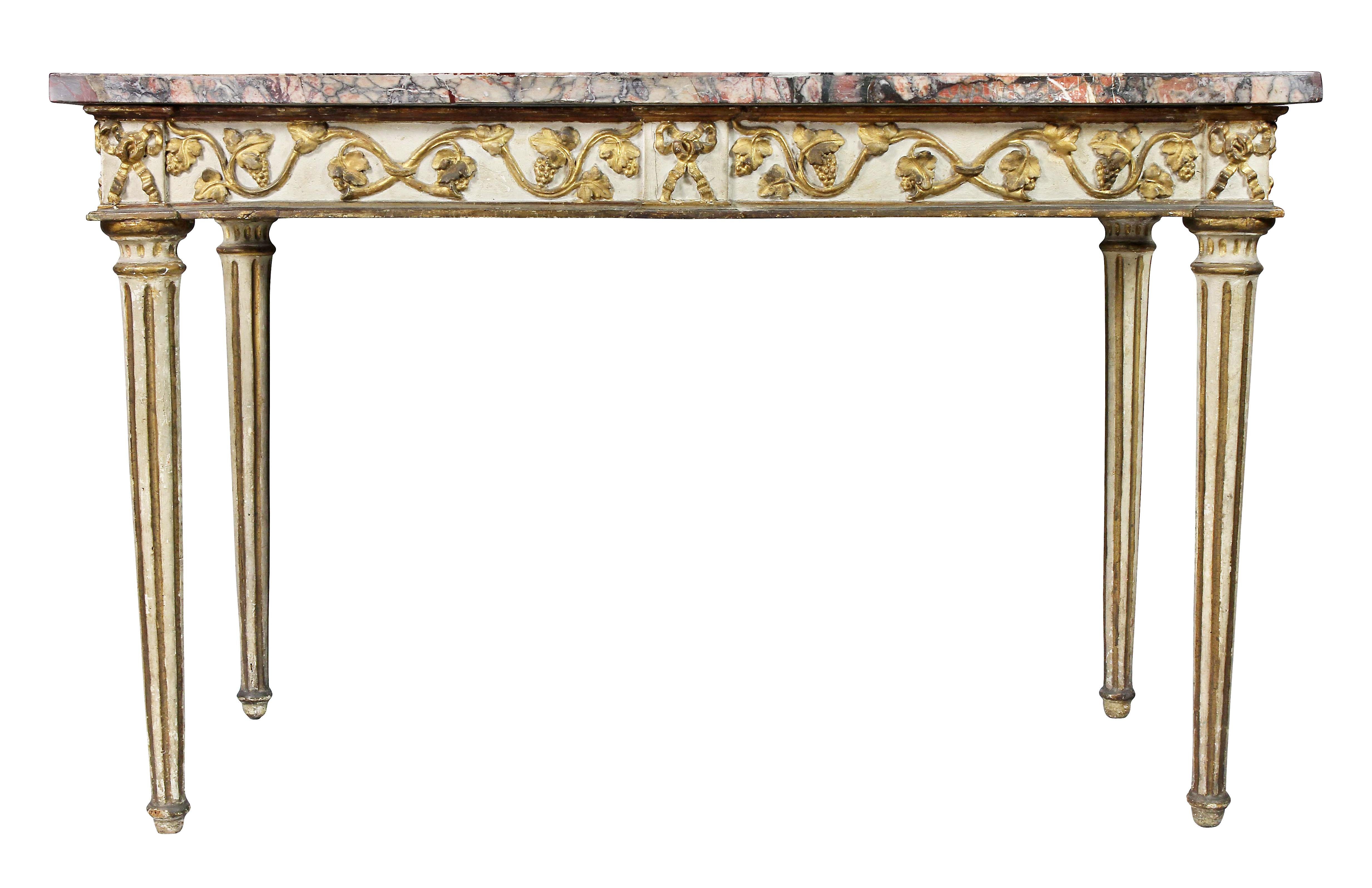 With a rectangular veneered marble top over a conforming frieze decorated with trailing grape vine and leaves and grapes, raised on circular tapered fluted legs.