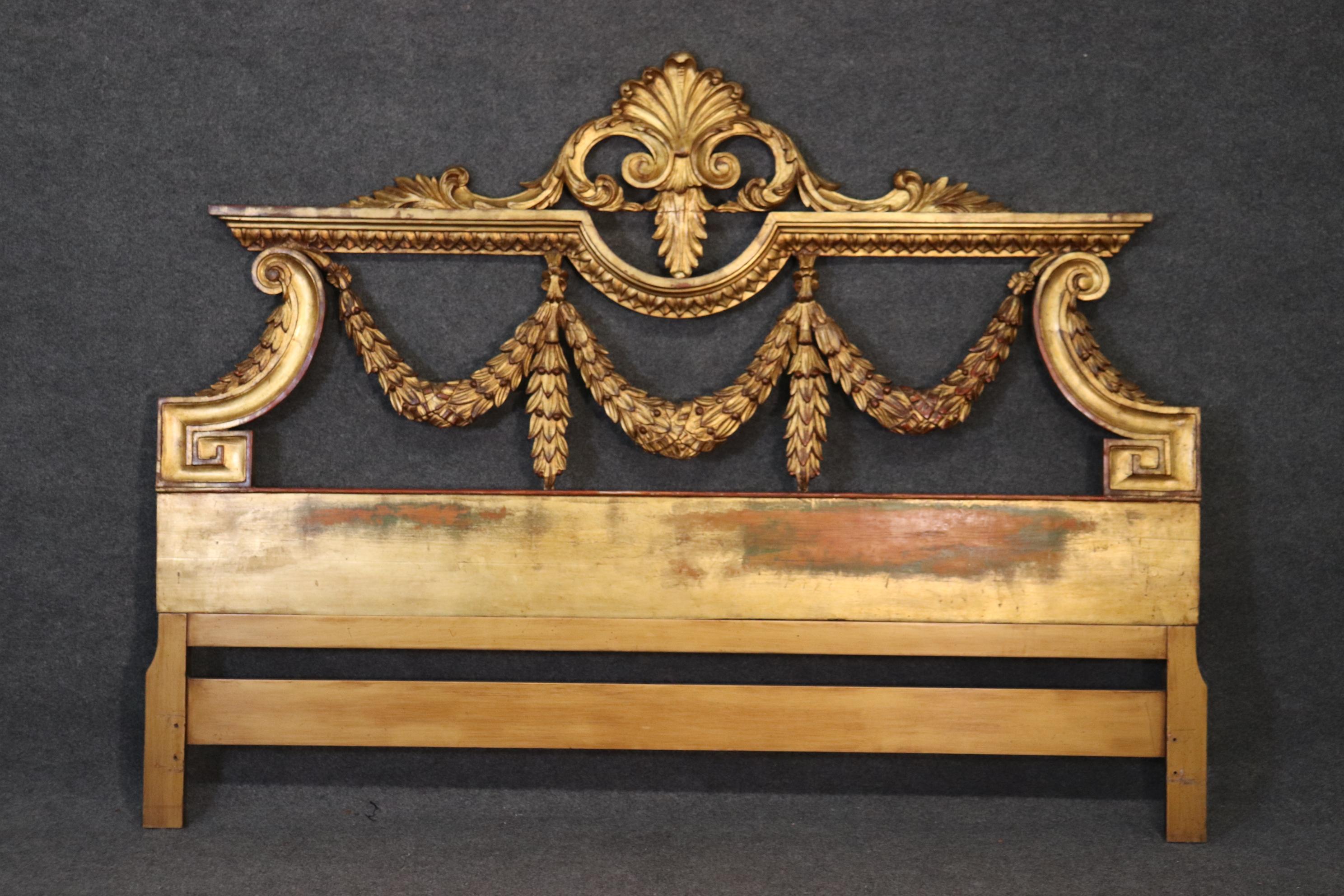 This is a gorgeous genuine gold leafed carved walnut headboard. The finish is in good vintage condition and has a wonderful patina. The beds dates to the 1950s era and can easily work with Hollywood Regency and other styles. Measures 80 inches wide
