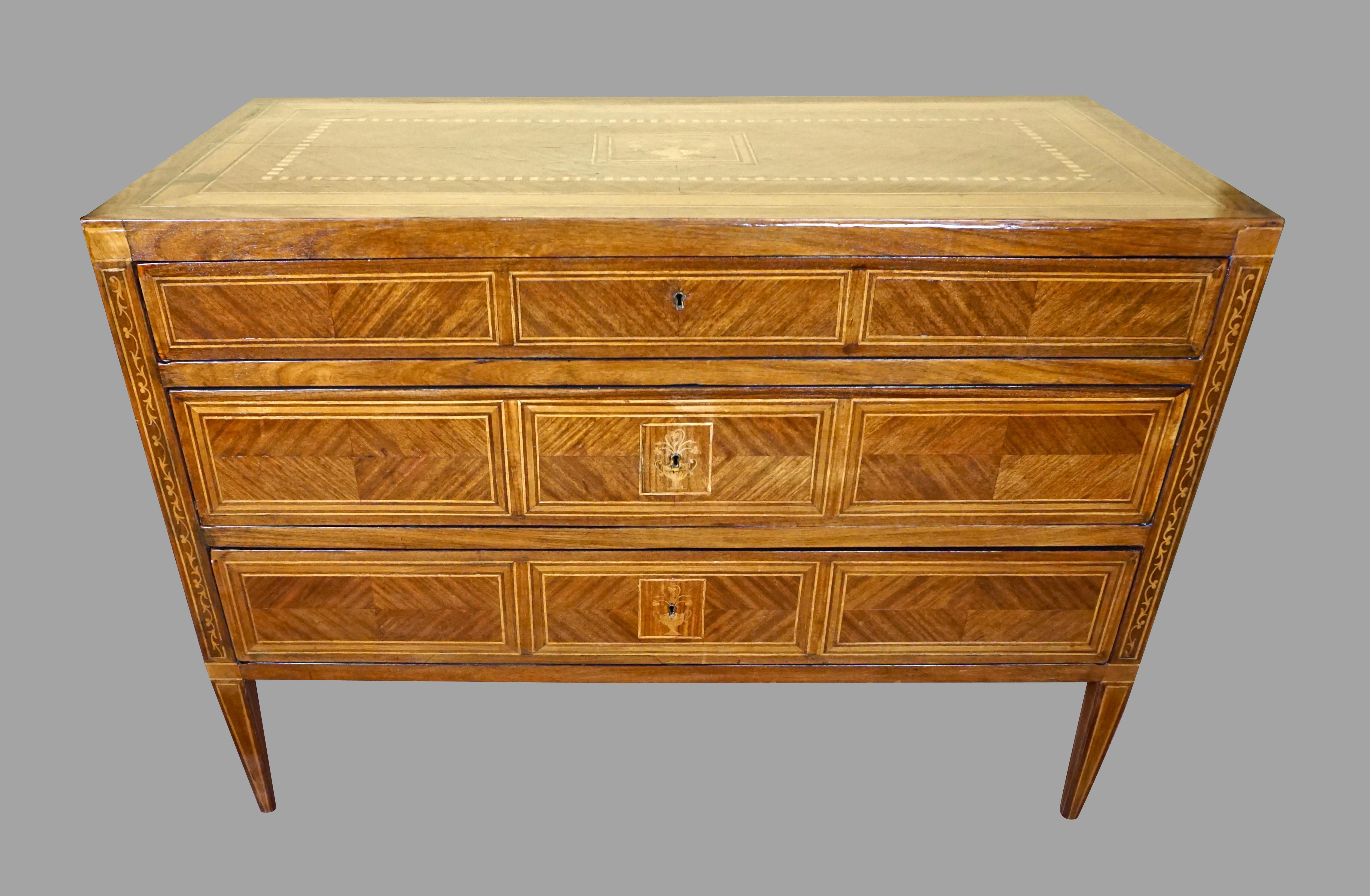 A substantial 18th century Italian Neoclassical period walnut 3-drawer commode, inlaid overall with rosewood, fruitwood and boxwood marquetry, the narrow top drawer over two additional deeper drawers supported on line inlaid taped legs. Bears the