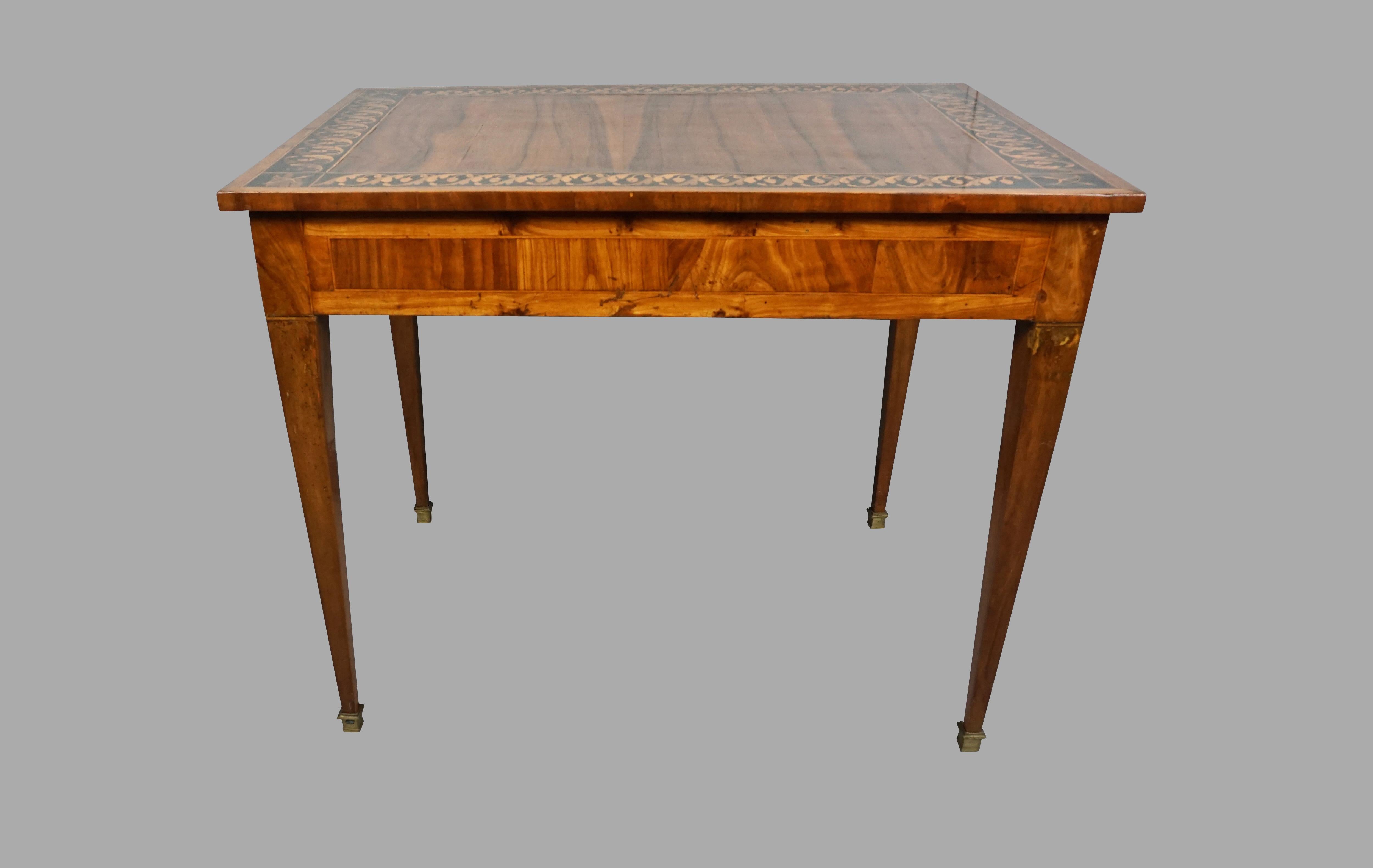 A very pretty Italian inlaid walnut writing table, the well-figured top with acorn and oak leaf crossbanding and bow and arrow decoration at the corners, over a single drawer, supported on square tapered legs ending in block feet, circa 1790.