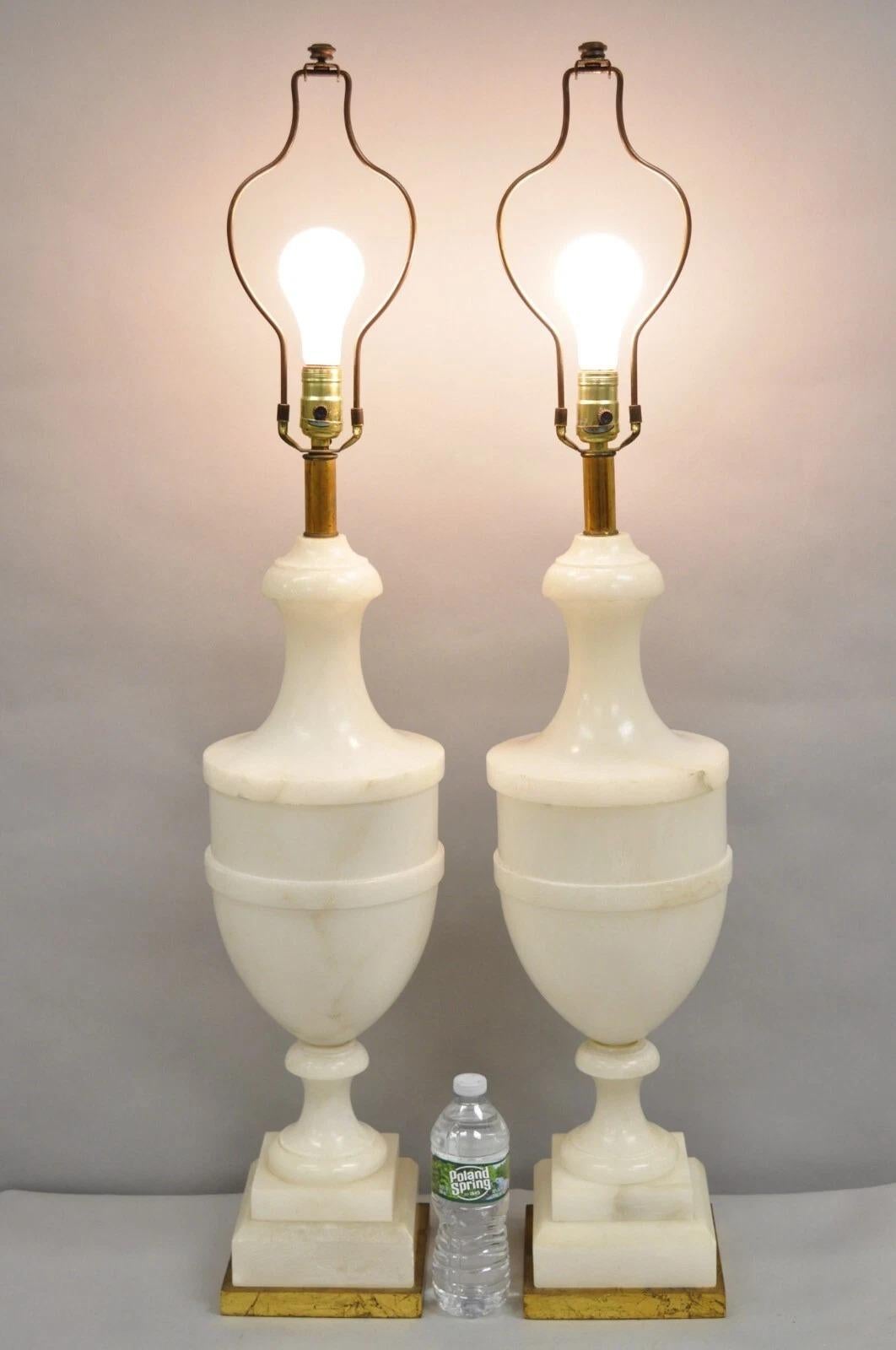Stately Antique Italian Neoclassical Large Carved Solid Alabaster Marble Urn Form Table Lamps on Gold Gilt Wood Bases - a Pair. Item features a high-quality, heavy construction, approx 30 lbs each. Circa Early 20th Century. Measurements: 41