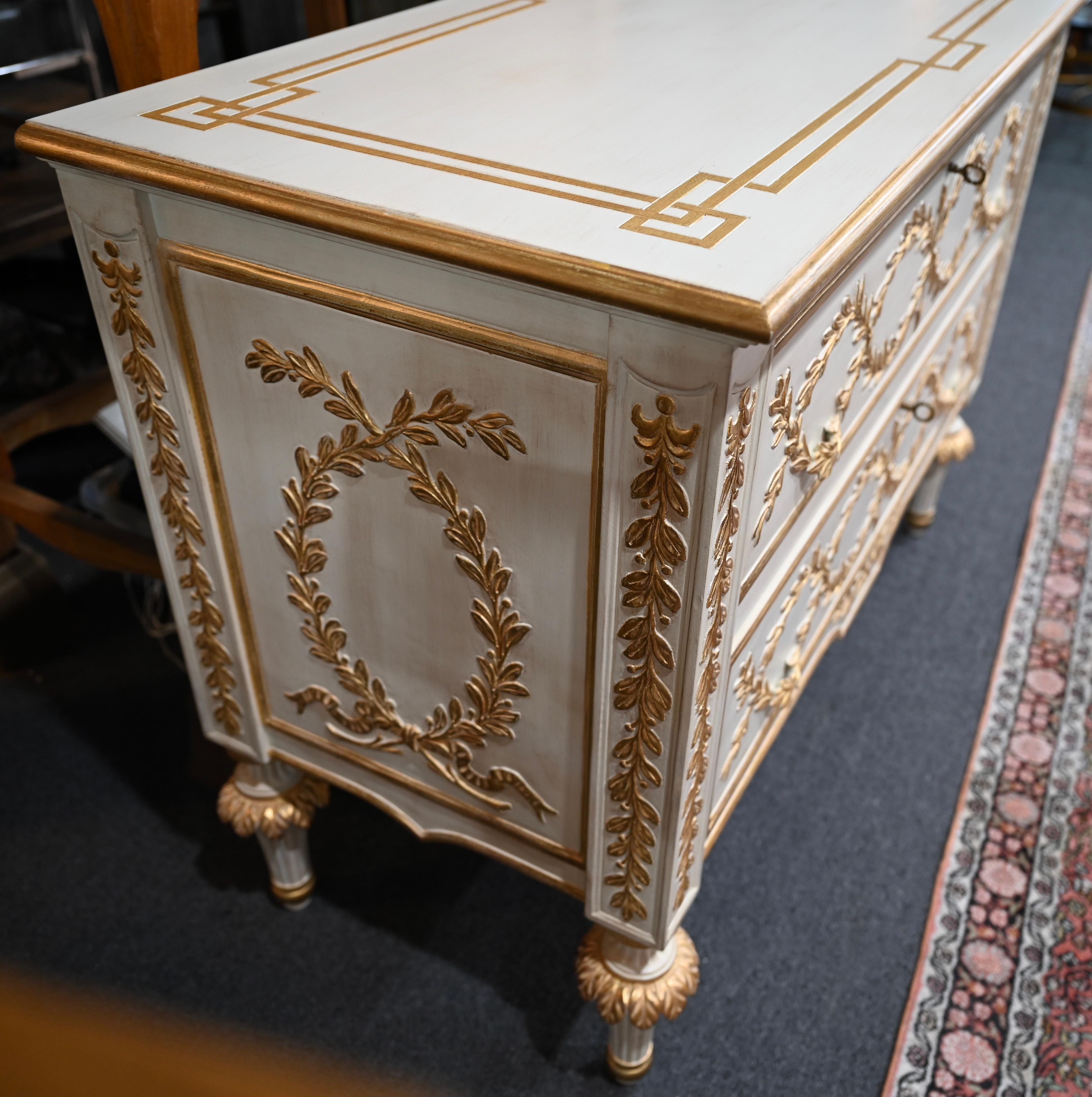 A fine Italian Neoclassical Louis XVI Style Chest of Drawers. This beautiful beige toned chest of drawers with gold leaf finished laurels is made in Florence, Italy. It embodies all the traditional details of very high quality Florentine furniture.