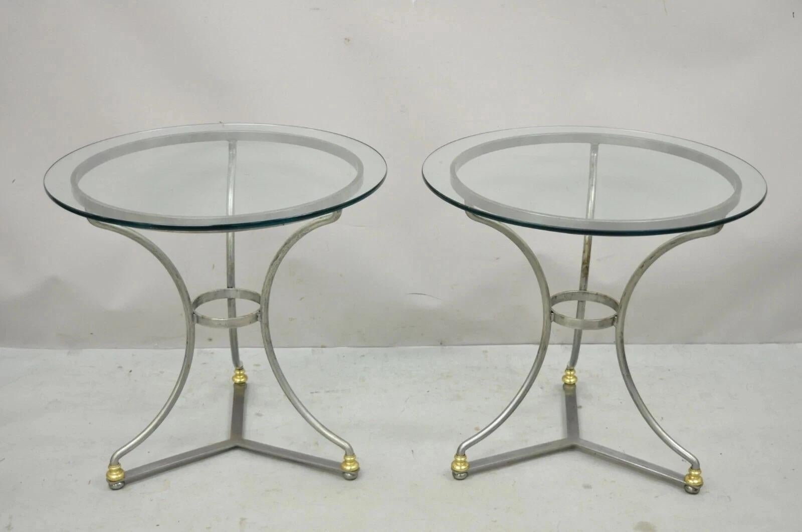 Tavolini rotondi d'epoca in stile neoclassico italiano della Maison Jansen in acciaio spazzolato e ottone - una coppia. L'articolo è caratterizzato da strutture in metallo spazzolato, accenti in ottone, finitura intenzionalmente