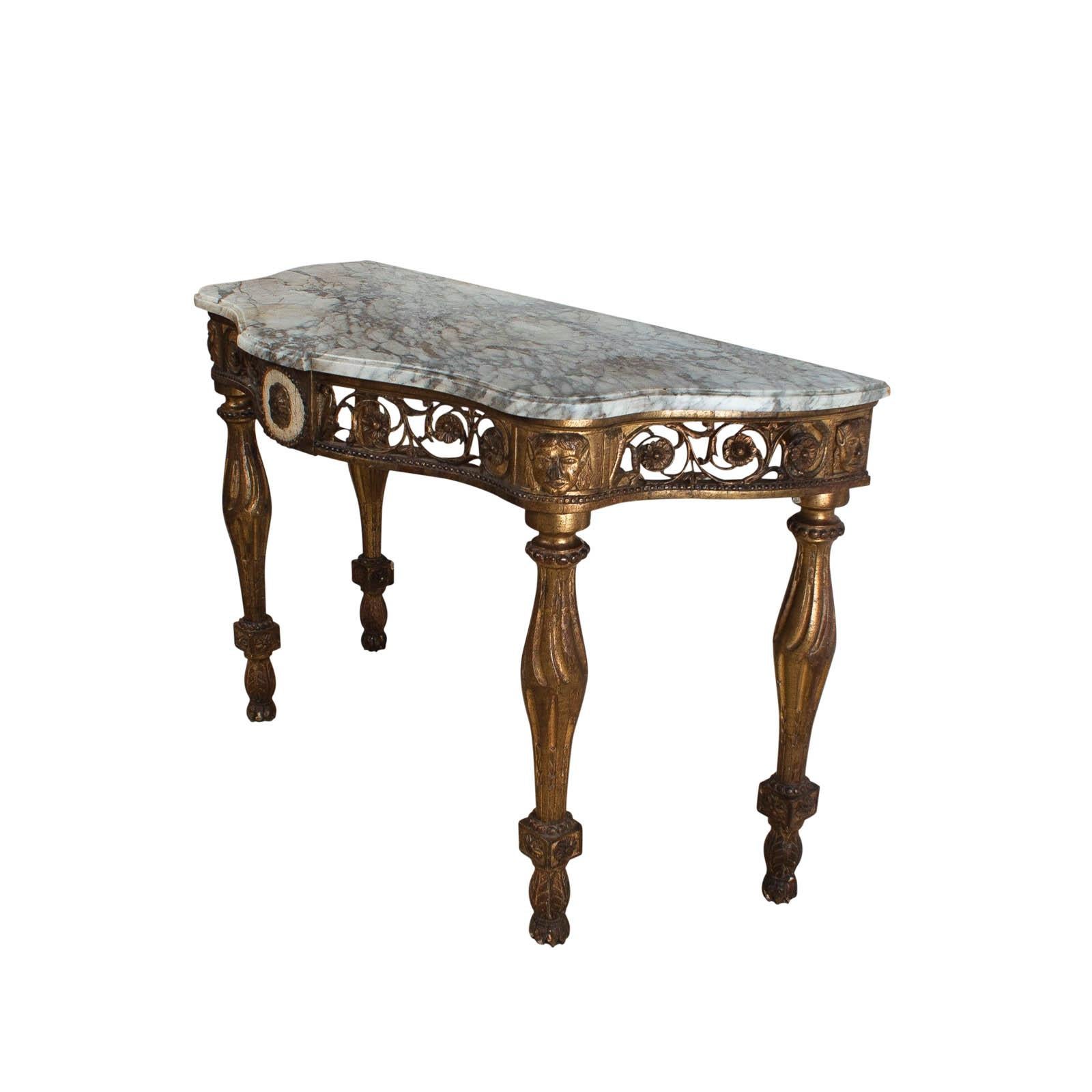 An early 19th century Italian neoclassical mecca gilt console with a later white and grey marble top, drilled for two lamp cords. Scrolling pierced rosettes flank a central medallion featuring a mecca gilt rosette on a white painted panel surrounded