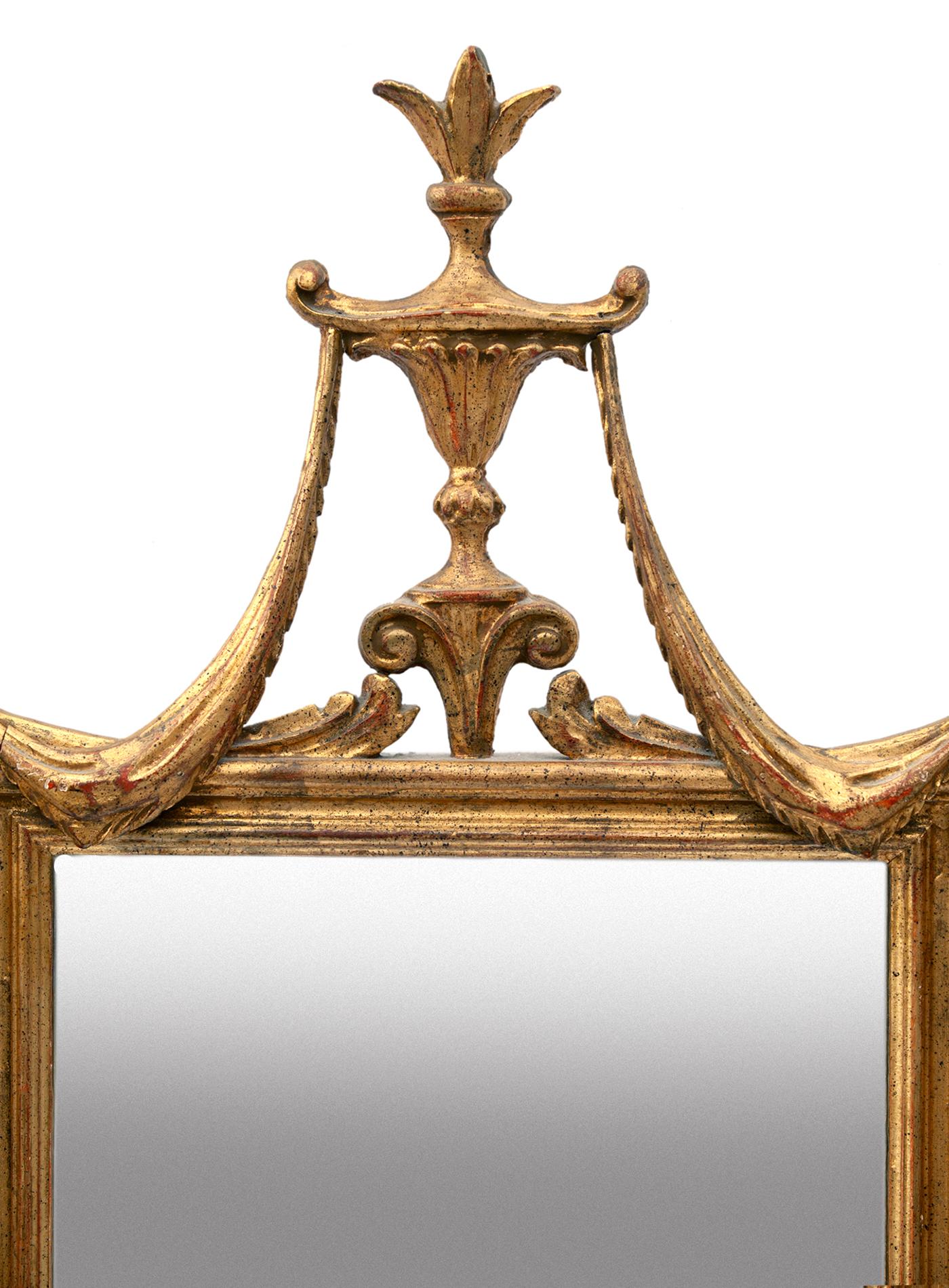 Un cadre rectangulaire en bois doré surmonté d'une urne qui porte de part et d'autre de spectaculaires guirlandes drapées.
Le miroir original est placé dans un magnifique cadre en résine dorée.
Une grande pièce d'apparat qui mettra en valeur