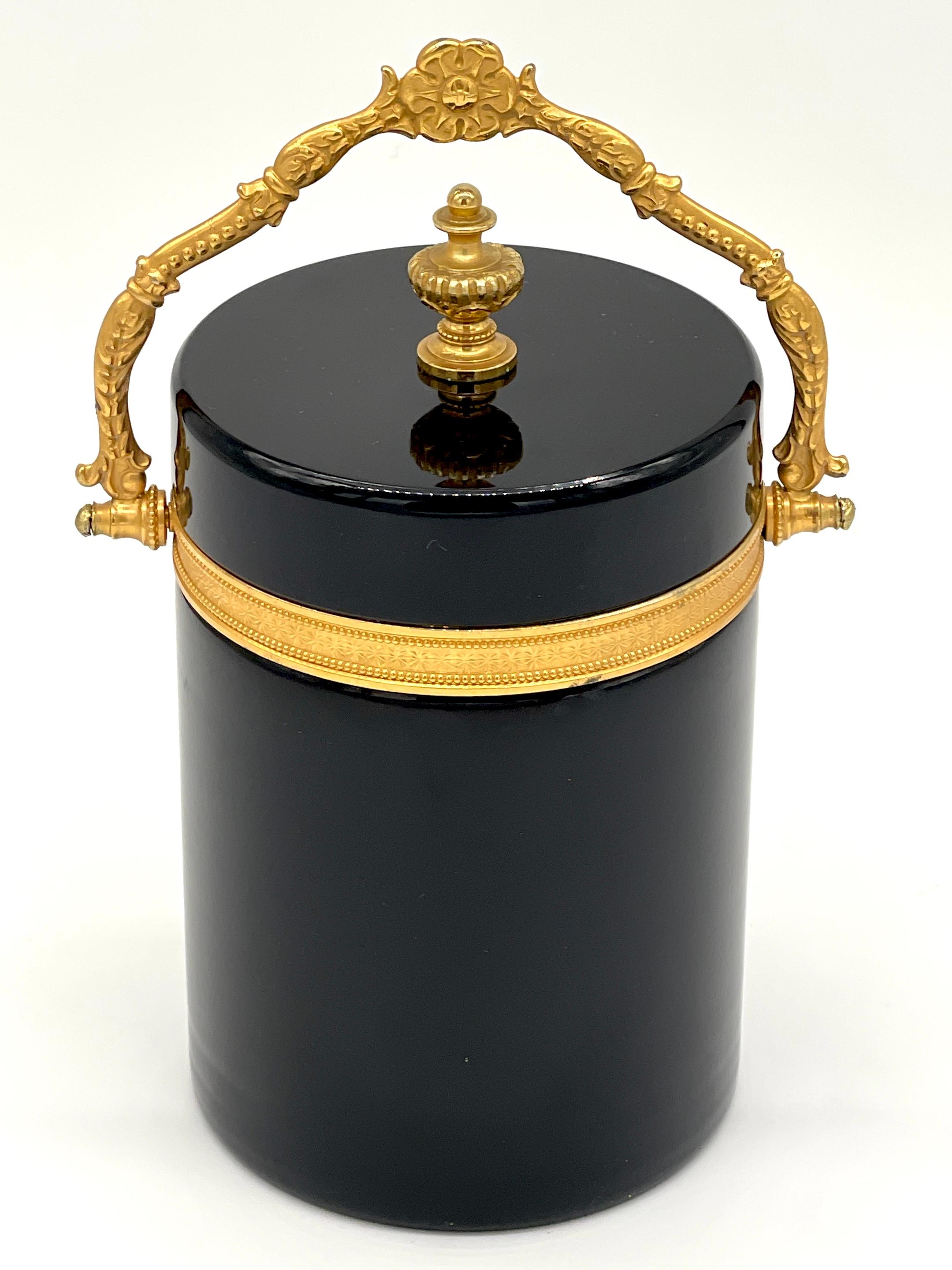 Seau à glace néoclassique italien monté en bronze doré et opaline de Murano avec poignée en forme de boîte
Italie, Circa 1960

Pièce élégante et captivante de l'artisanat italien, cette boîte/seau à glace néoclassique en opaline noire de Murano