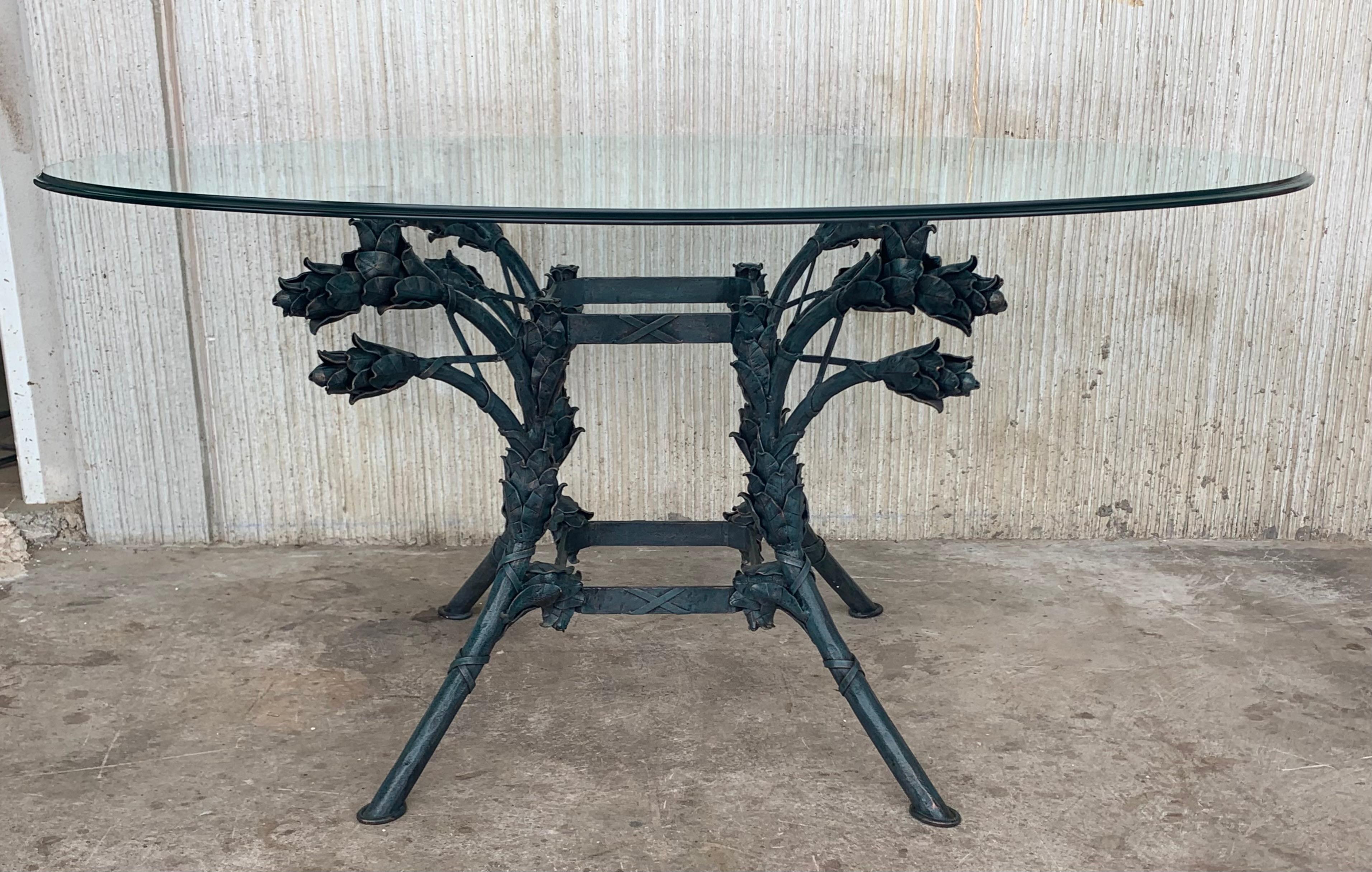 Dramatic Italian centre table with oval glass top supported by an iron base with scroll legs embellished with flowers. Very impressive with vibrant colors and ornate decoration. Could also be used as a small dining or breakfast table.