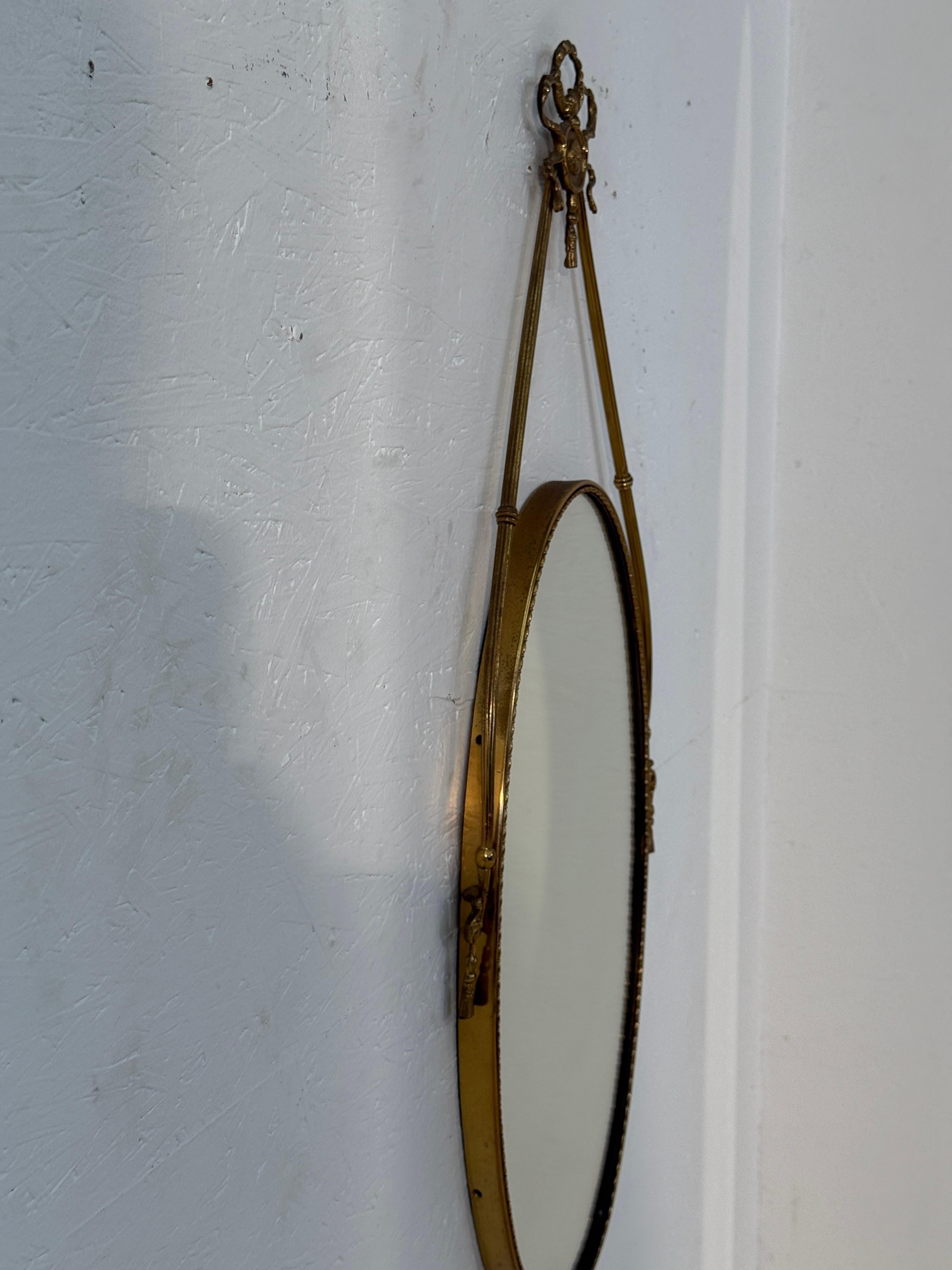 Italian Neoclassical Oval Mirror with Brass Ribbon and Tassel Detailing, 1950s In condizioni buone in vendita a Los Angeles, CA